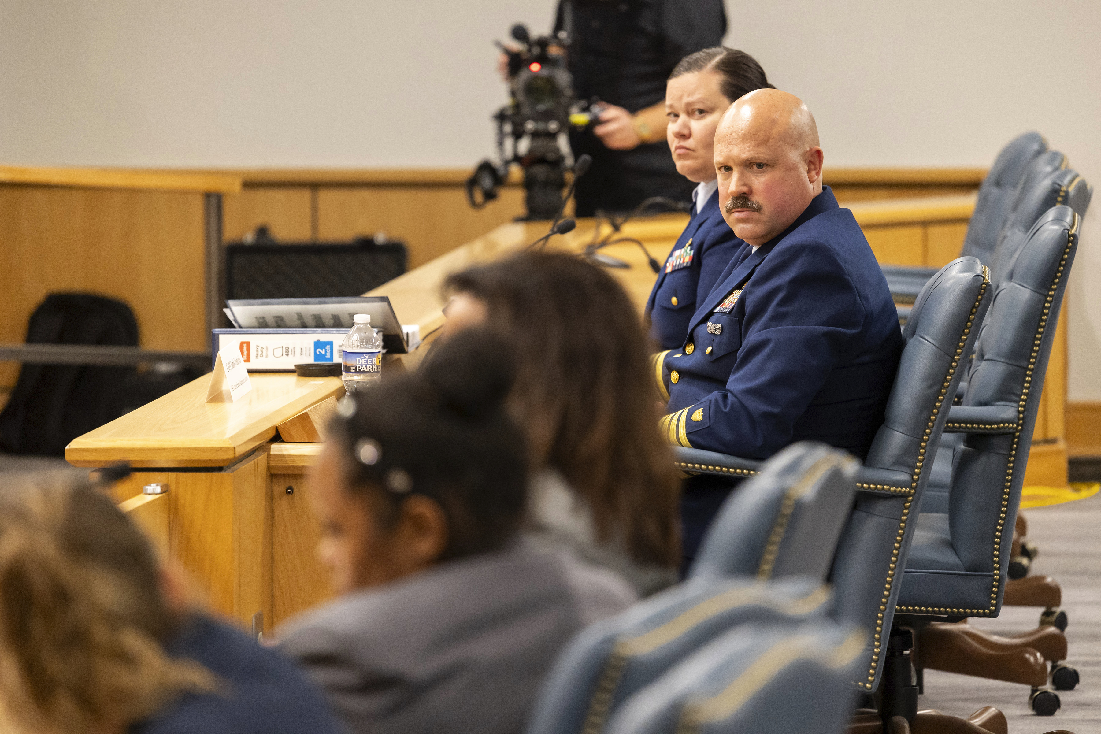 Jamie Frederick, at right, with the U.S. Coast Guard Sector Boston, and Coast Guard legal counsel Jessie Brenton listen to OceanGate Counsel speak during the final day of the Coast Guard investigatory hearing on the causes of the implosion of an experimental submersible headed for the wreck of the Titanic, Friday, Sept. 27, 2024, in North Charleston, S.C. (AP Photo/Mic Smith)