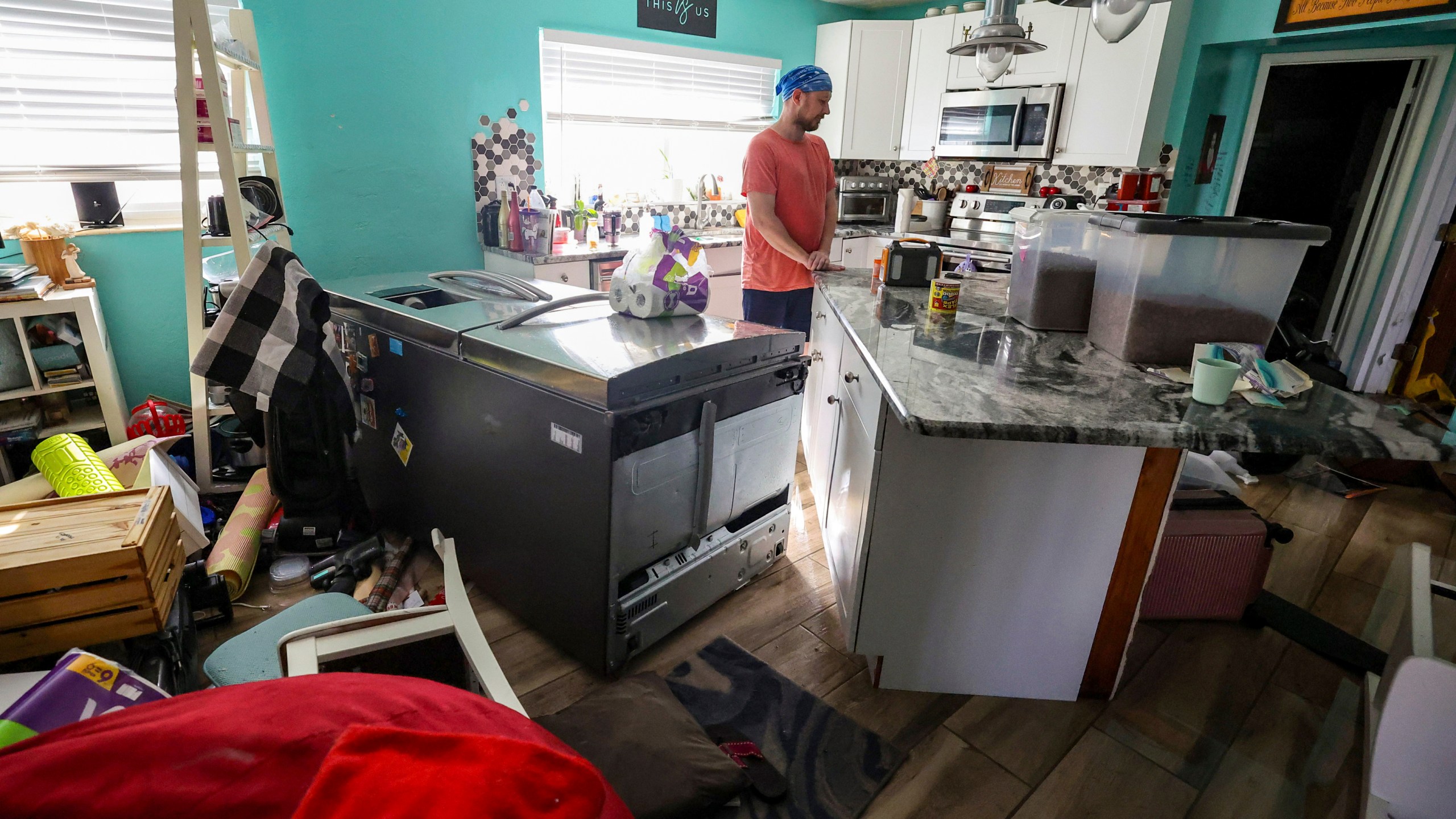 Bradley Tennant looks through his house flooded with water from Hurricane Helene in the Shore Acres neighborhood Friday, Sept. 27, 2024, in St. Petersburg, Fla. (AP Photo/Mike Carlson)