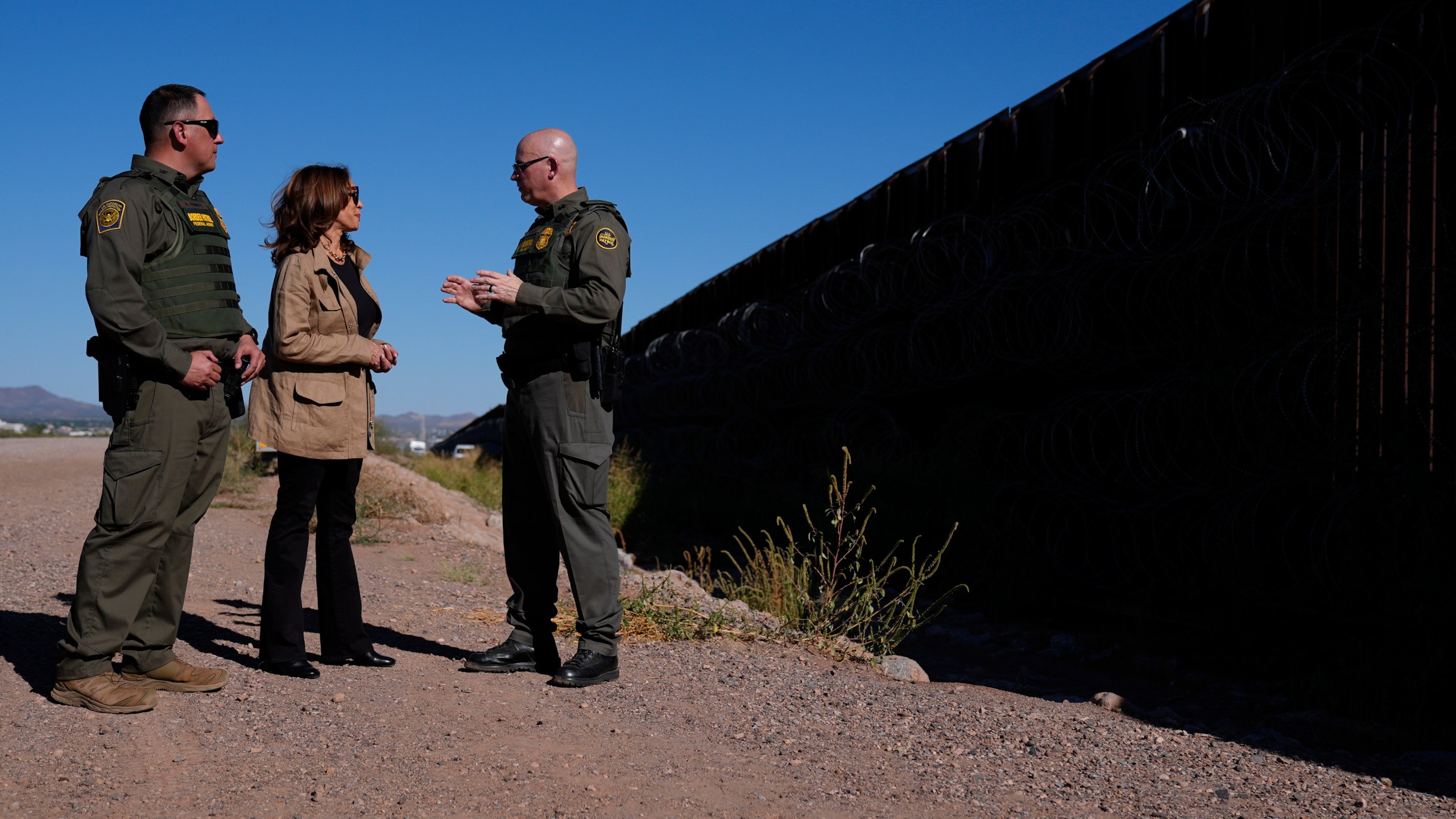 Democratic presidential nominee Vice President Kamala Harris talks with John Modlin, the chief patrol agent for the Tucson Sector of the U.S. Border Patrol, right, and Blaine Bennett, the U.S. Border Patrol Douglas Station border patrol agent in charge, as she visits the U.S. border with Mexico in Douglas, Ariz., Friday, Sept. 27, 2024. (AP Photo/Carolyn Kaster)