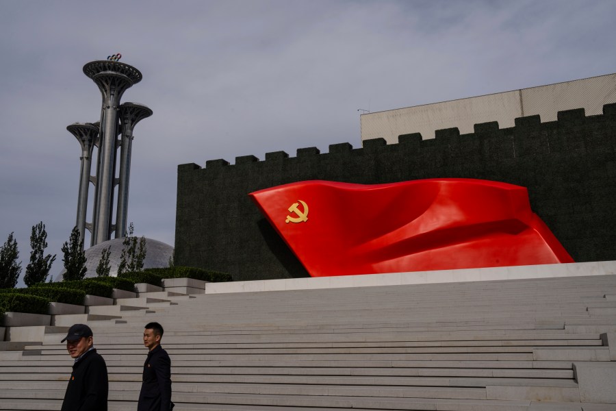 FILE - Visitors pass the Chinese Communist Party flag at the museum of the Communist Party of China in Beijing, Oct. 19, 2023. (AP Photo/Louise Delmotte, File)