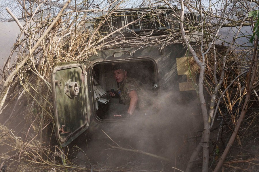 Ukrainian serviceman of 56th brigade sits inside self-propelled artillery vehicle while firing towards Russian positions at the frontline on Chasiv Yar direction, Donetsk region, Ukraine, Sept. 27, 2024. (AP Photo/Evgeniy Maloletka)