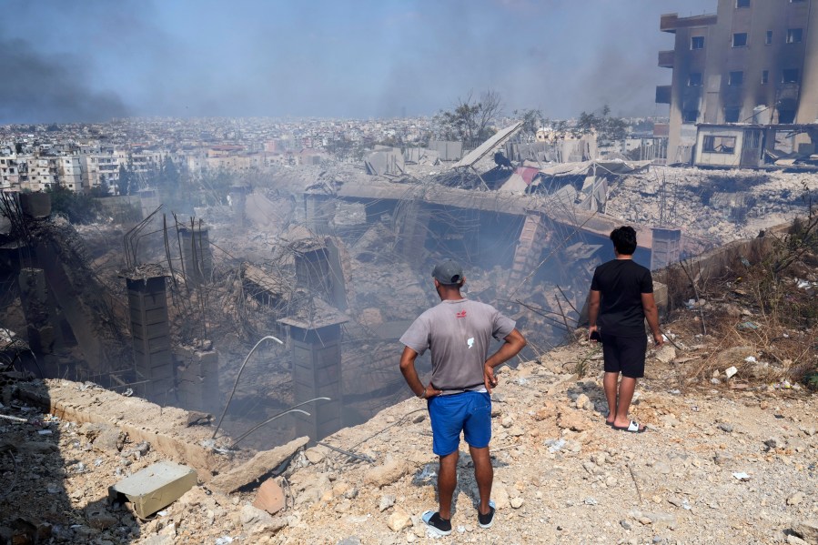 People check a damaged building at the site of an Israeli airstrike in Choueifat, south east of Beirut, Saturday, Sept. 28, 2024. (AP Photo/Hussein Malla)