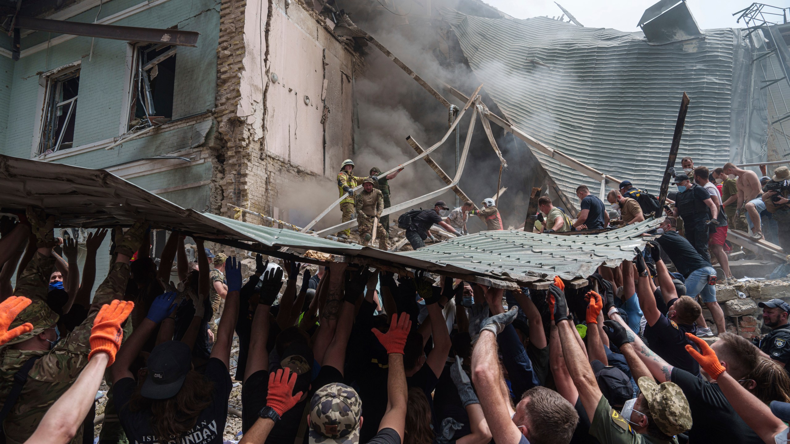 FILE - Rescuers work together to clear debris during a search operation for survivors at the Okhmatdyt children's hospital that was hit by a Russian missile, in Kyiv, Ukraine, July 8, 2024. (AP Photo/Evgeniy Maloletka, File)