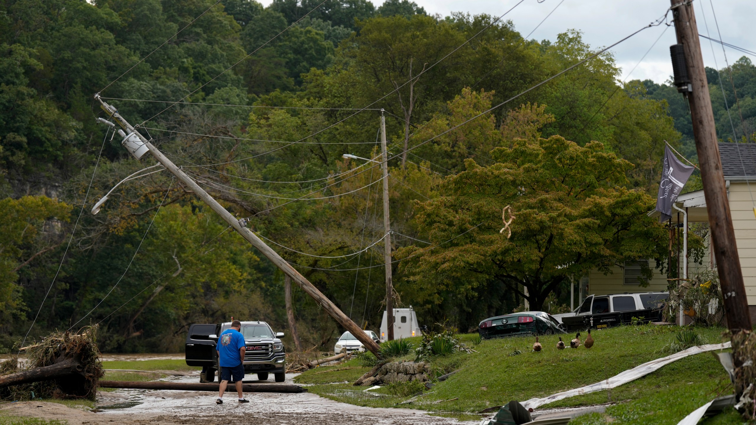 A person crosses River St. where flood damage is seen Saturday, Sept. 28, 2024, in Newport, Tenn. (AP Photo/George Walker IV)