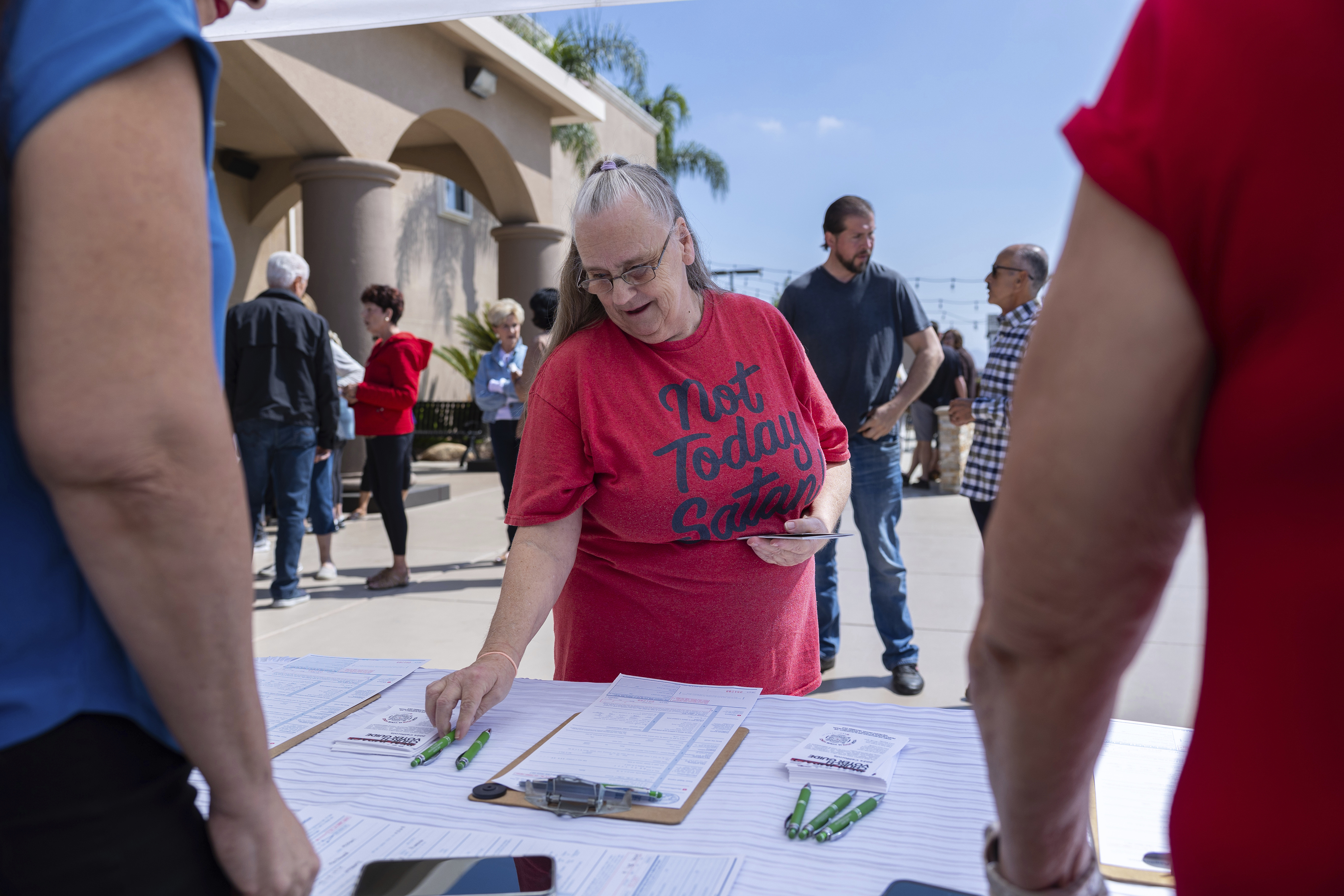 Janet Berkeley stops by a voter registration desk during a Comeback California Tour event at Revival Fellowship, Saturday, Sept. 21, 2024, in Menifee, Calif. (AP Photo/Zoë Meyers)