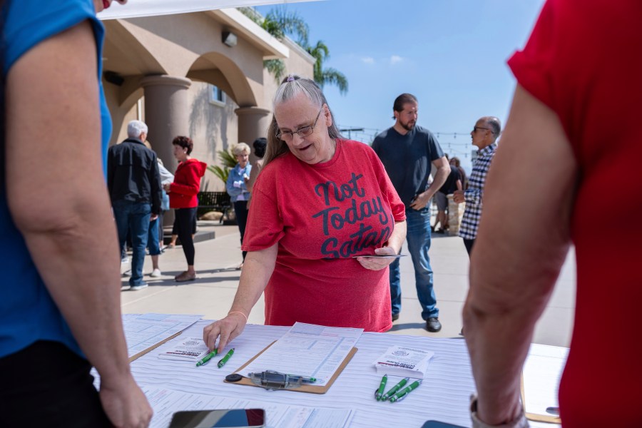 Janet Berkeley stops by a voter registration desk during a Comeback California Tour event at Revival Fellowship, Saturday, Sept. 21, 2024, in Menifee, Calif. (AP Photo/Zoë Meyers)