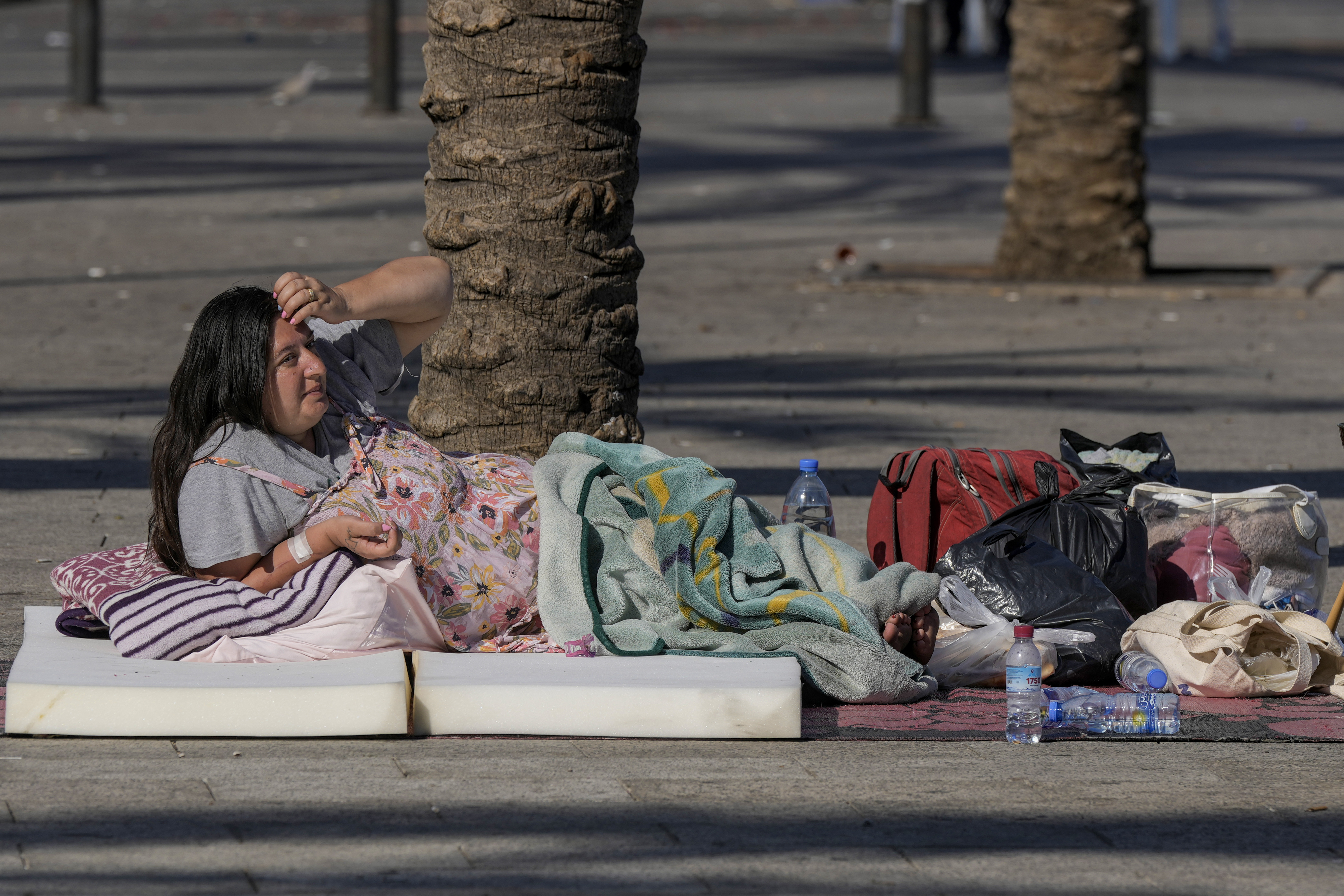 A woman sleeps on Beirut's corniche after fleeing the Israeli airstrikes in the southern suburbs of Dahiyeh, Sunday, Sept. 29, 2024. (AP Photo/Bilal Hussein)