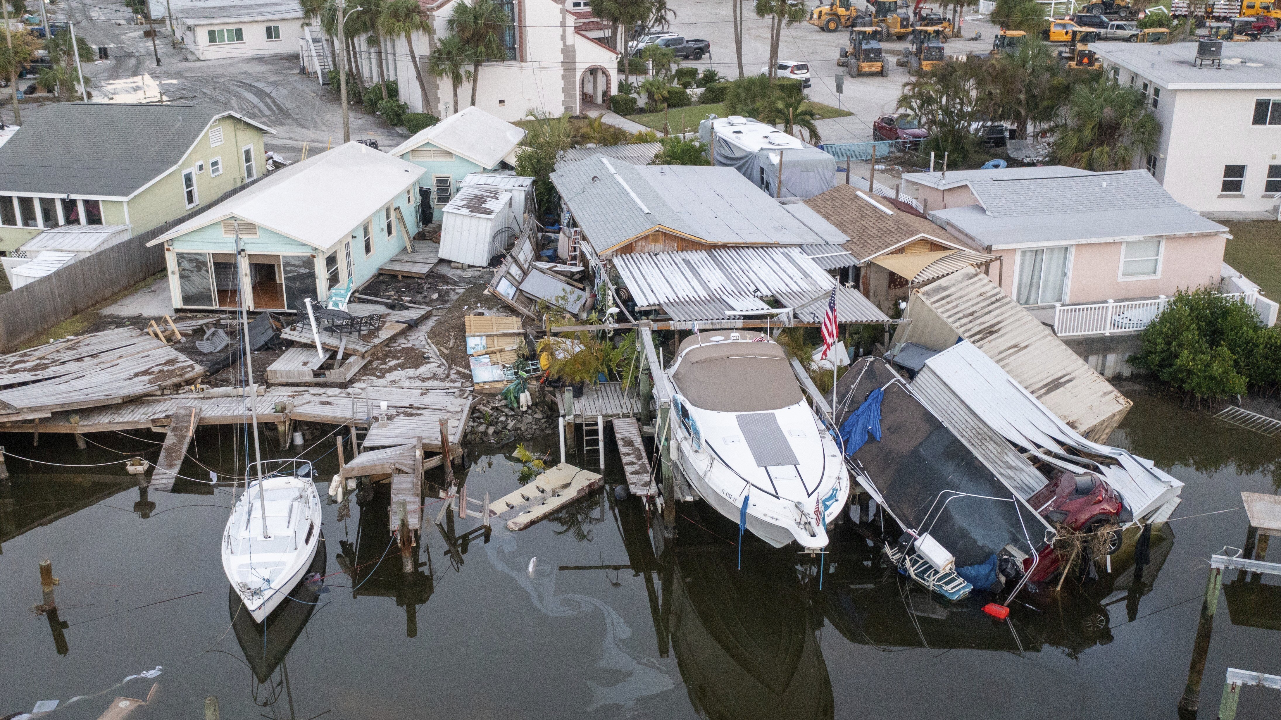 This aerial drone view shows damaged homes and a vehicle collapsed into water after storm surge from Hurricane Helene, Saturday, Sept. 28, 2024, in Madeira Beach, Fla. (Luis Santana/Tampa Bay Times via AP)