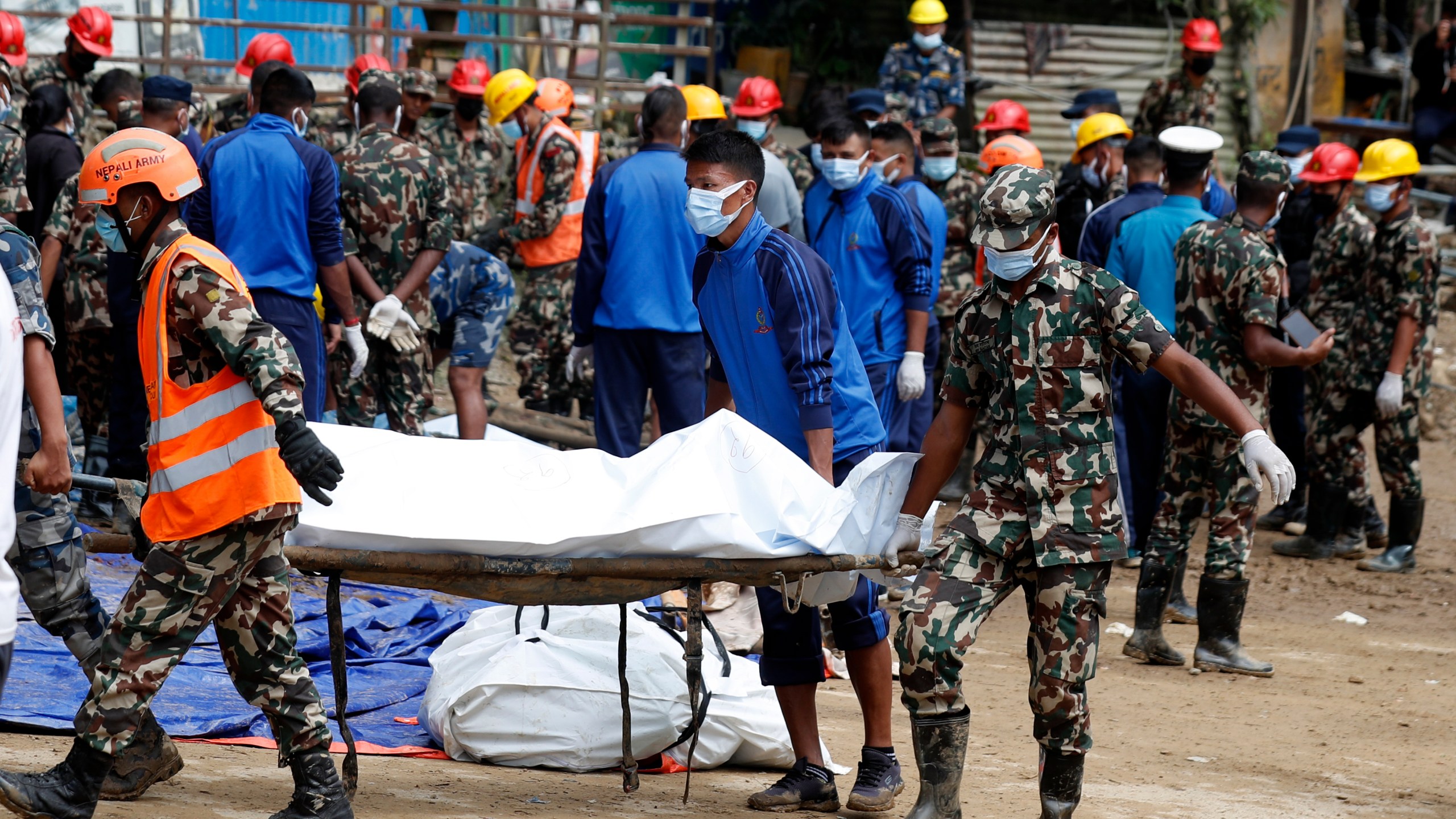 Rescue personnel transport the dead body of a victim who was trapped under a landslide caused by heavy rains in Kathmandu, Nepal, Sunday, Sept. 29, 2024. (AP Photo/Sujan Gurung)