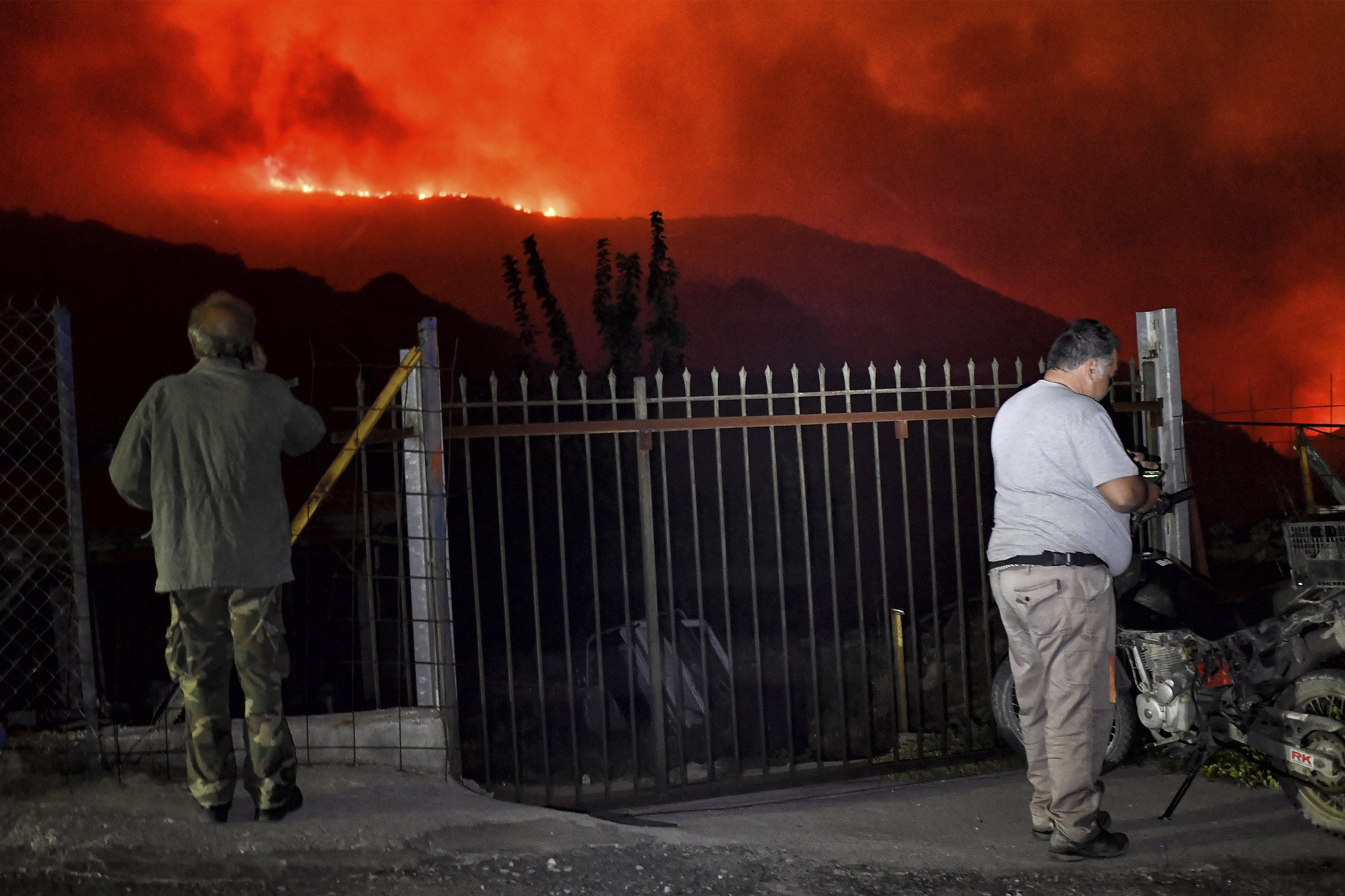 Residents watch a wildfire approaching the village of Kallithea as fanned by strong winds raged uncontrolled despite the attempts of hundreds of firefighters to stop it, some 149 kilometers (93 miles) west of Athens, Greece, in the region of Corinthia, late Sunday, Sept. 29, 2024. (AP Photo)