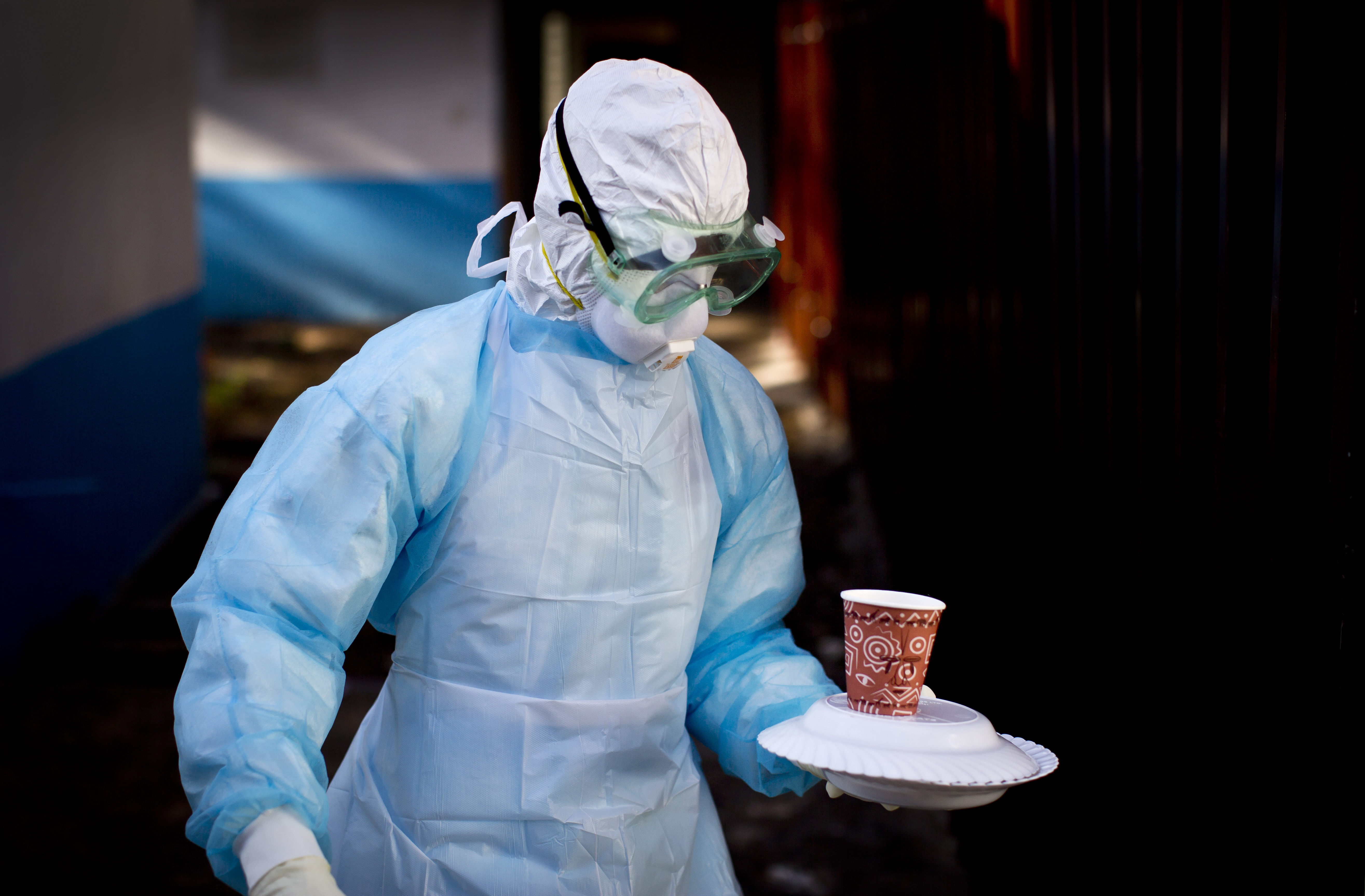 FILE - In this Oct. 8, 2014 photo, a medical worker from the Infection Prevention and Control unit wearing full protective equipment carries a meal to an isolation tent housing a man being quarantined after coming into contact in Uganda with a carrier of the Marburg Virus, at the Kenyatta National Hospital in Nairobi, Kenya. (AP Photo/Ben Curtis, File)