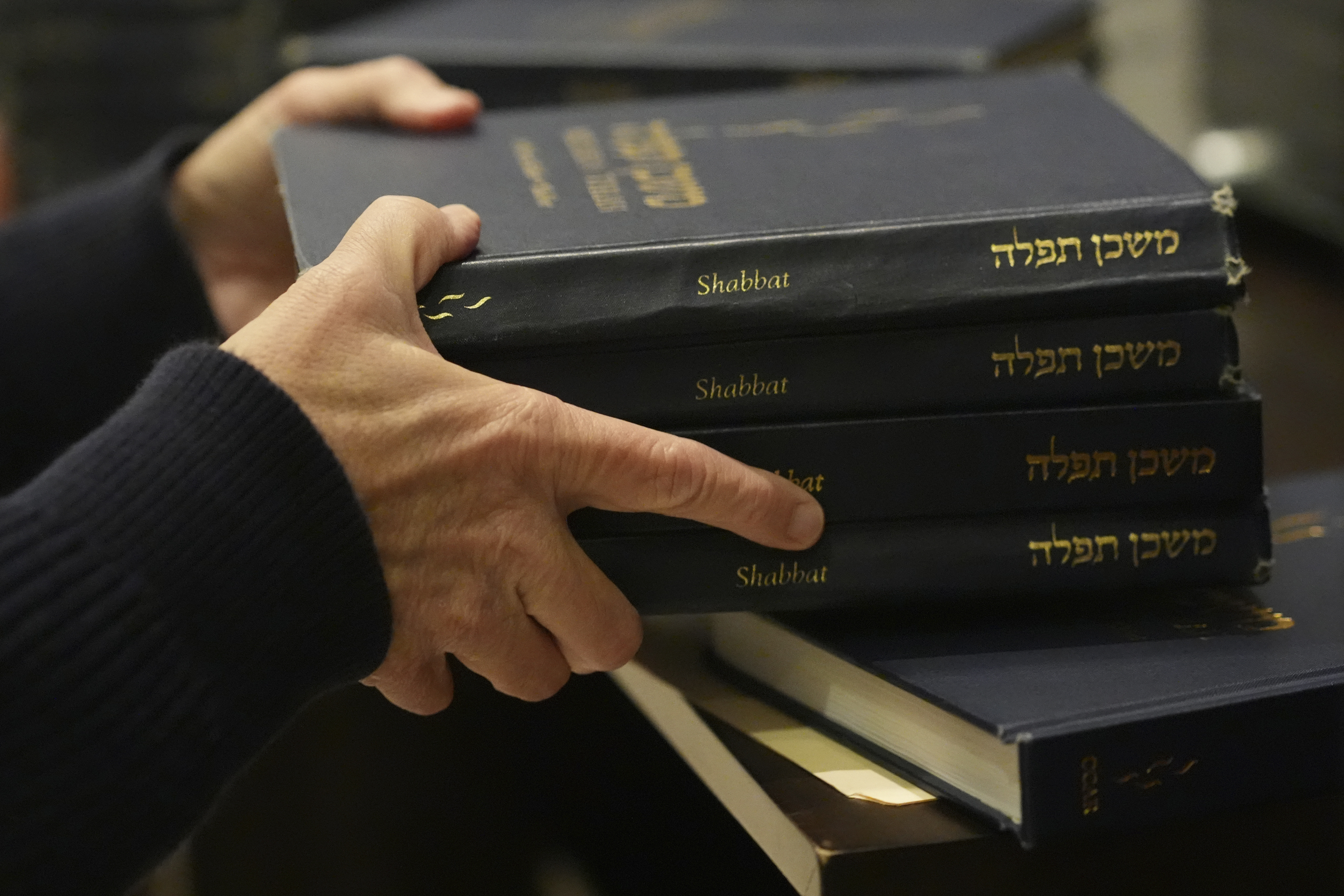 Craig Berko, director of membership at Temple Beth Sholom, prepares to hand out prayer books during a Shabbat service, Friday, Sept. 27, 2024, in Miami Beach, Fla. (AP Photo/Wilfredo Lee)