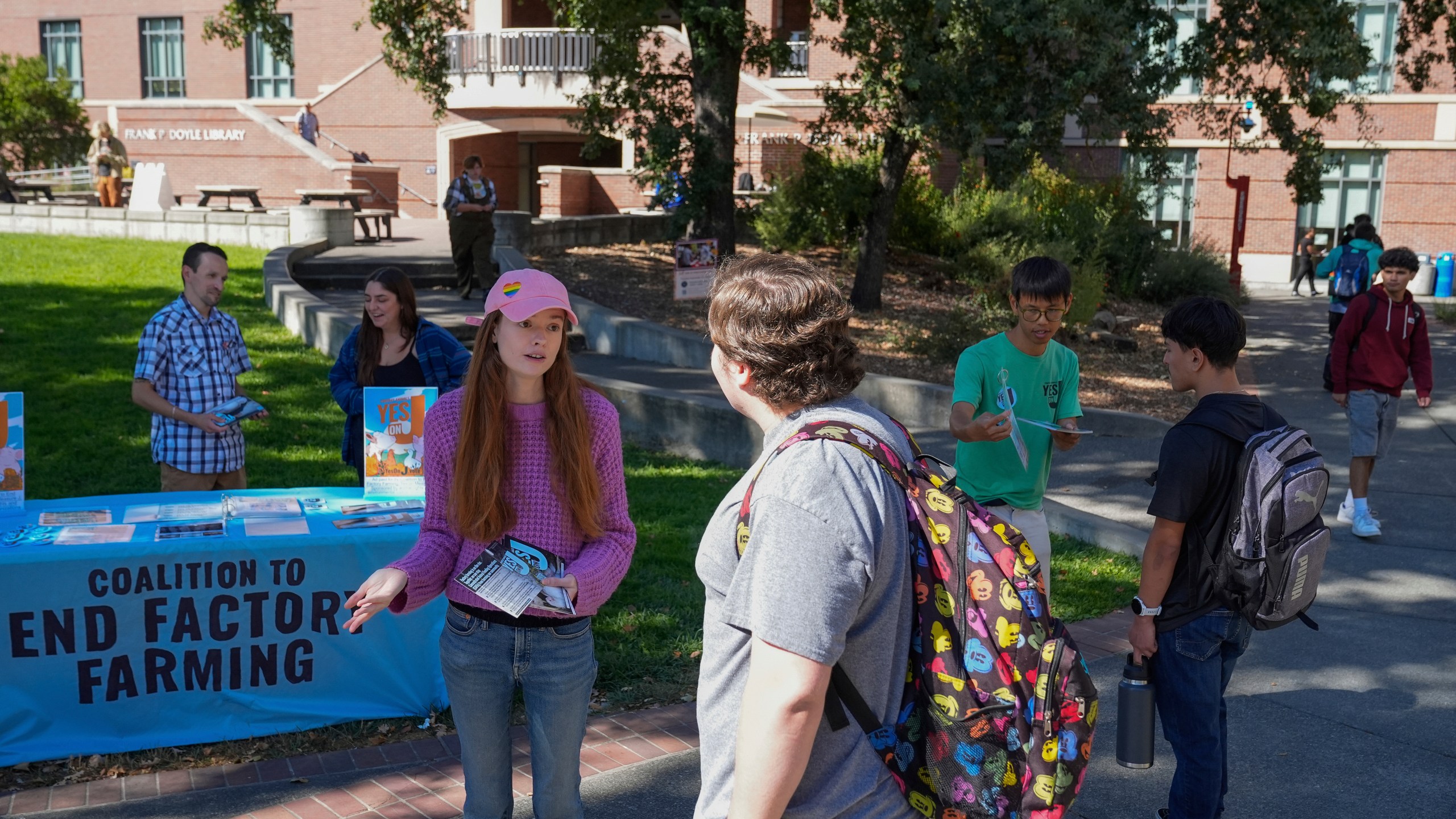 Cassie King, center left, talks to a student at Santa Rosa Junior College about voting yes on Measure J, Monday, Sept. 23, 2024, in Santa Rosa, Calif. (AP Photo/Godofredo A. Vásquez)