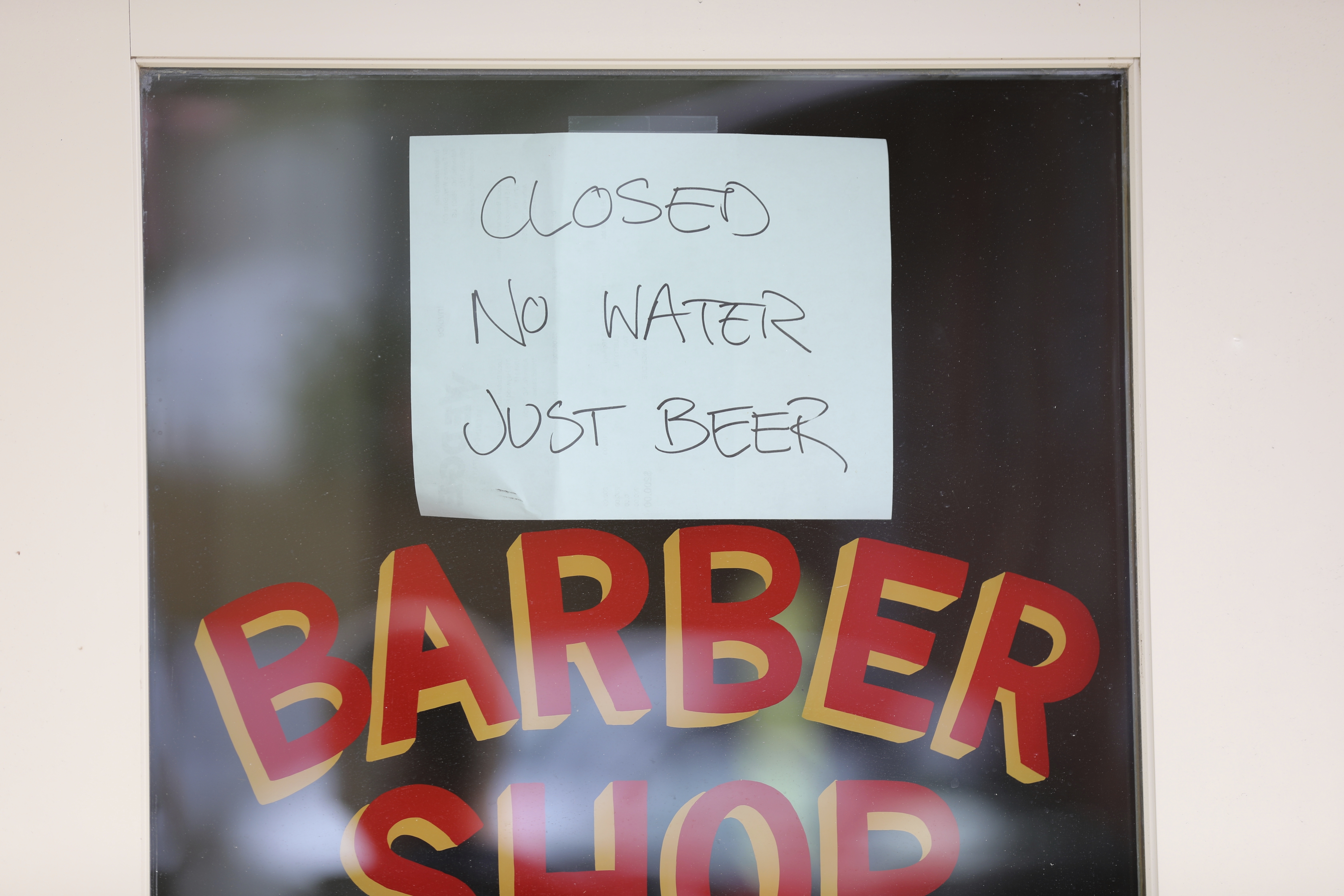 A sign hangs outside a closed barber shop and bar in Asheville, N.C., Monday, Sept. 30, 2024. (AP Photo/Jeffrey Collins)