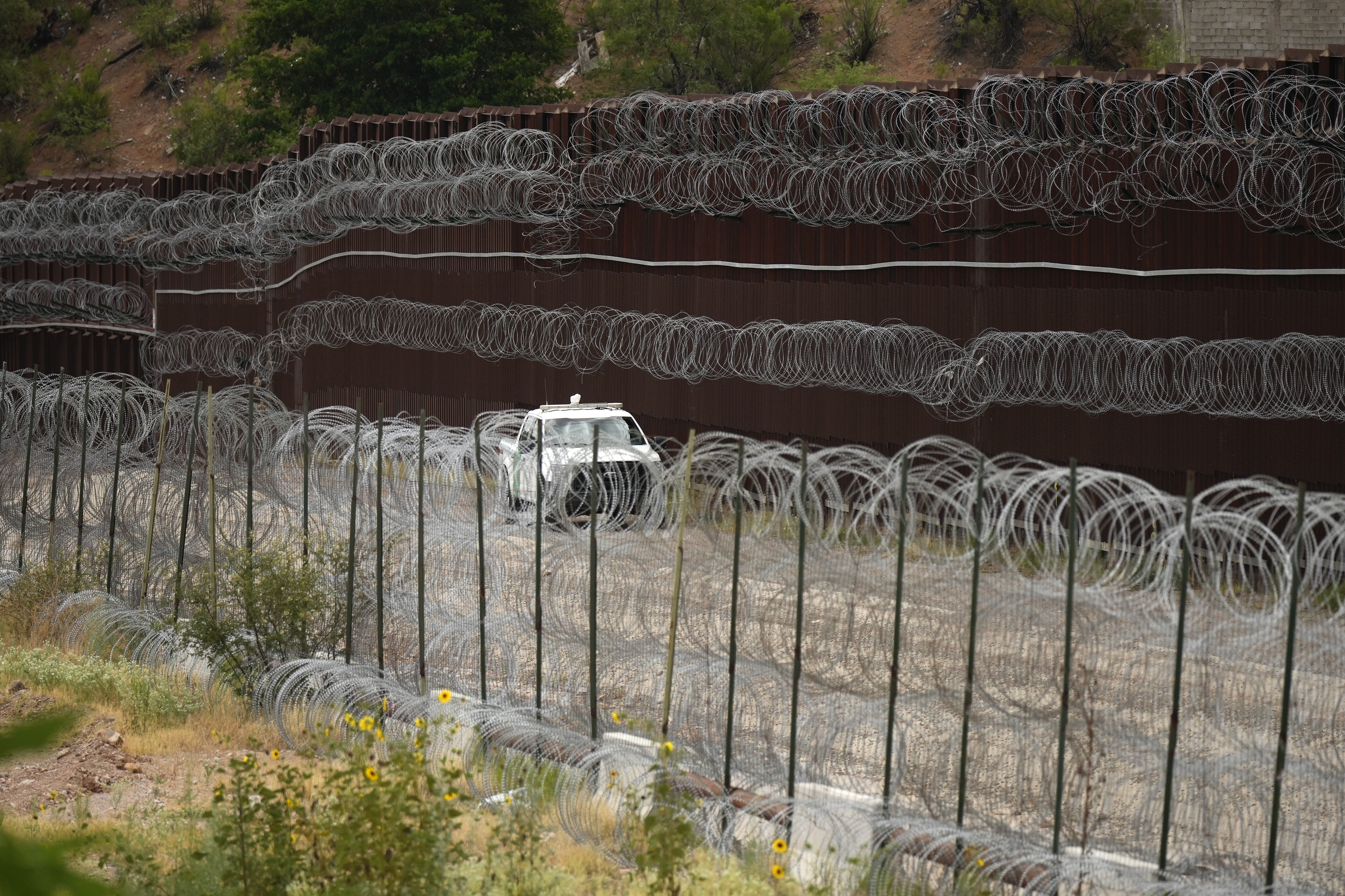 FILE - A vehicle drives along the U.S. side of the US-Mexico border wall in Nogales, Ariz., June 25, 2024. The Biden administration is making asylum restrictions at the southern border even tougher. The changes come in the middle of an election campaign where border security is a key concern for voters, and the administration is increasingly eager to show voters it's taking a hard stance. (AP Photo/Jae C. Hong, Pool, File)