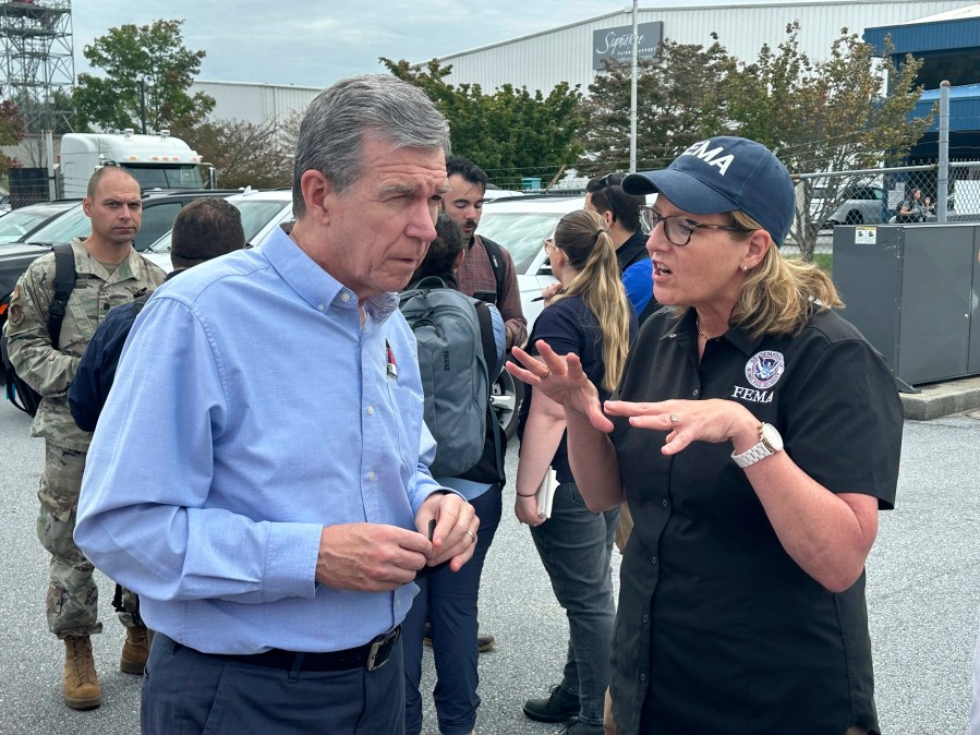 North Carolina Gov. Roy Cooper speaks with FEMA Administrator Deanne Criswell on Monday, Sept. 30, at the Asheville Regional Airport in Fletcher, N.C. (AP Photo/Gary Robertson)