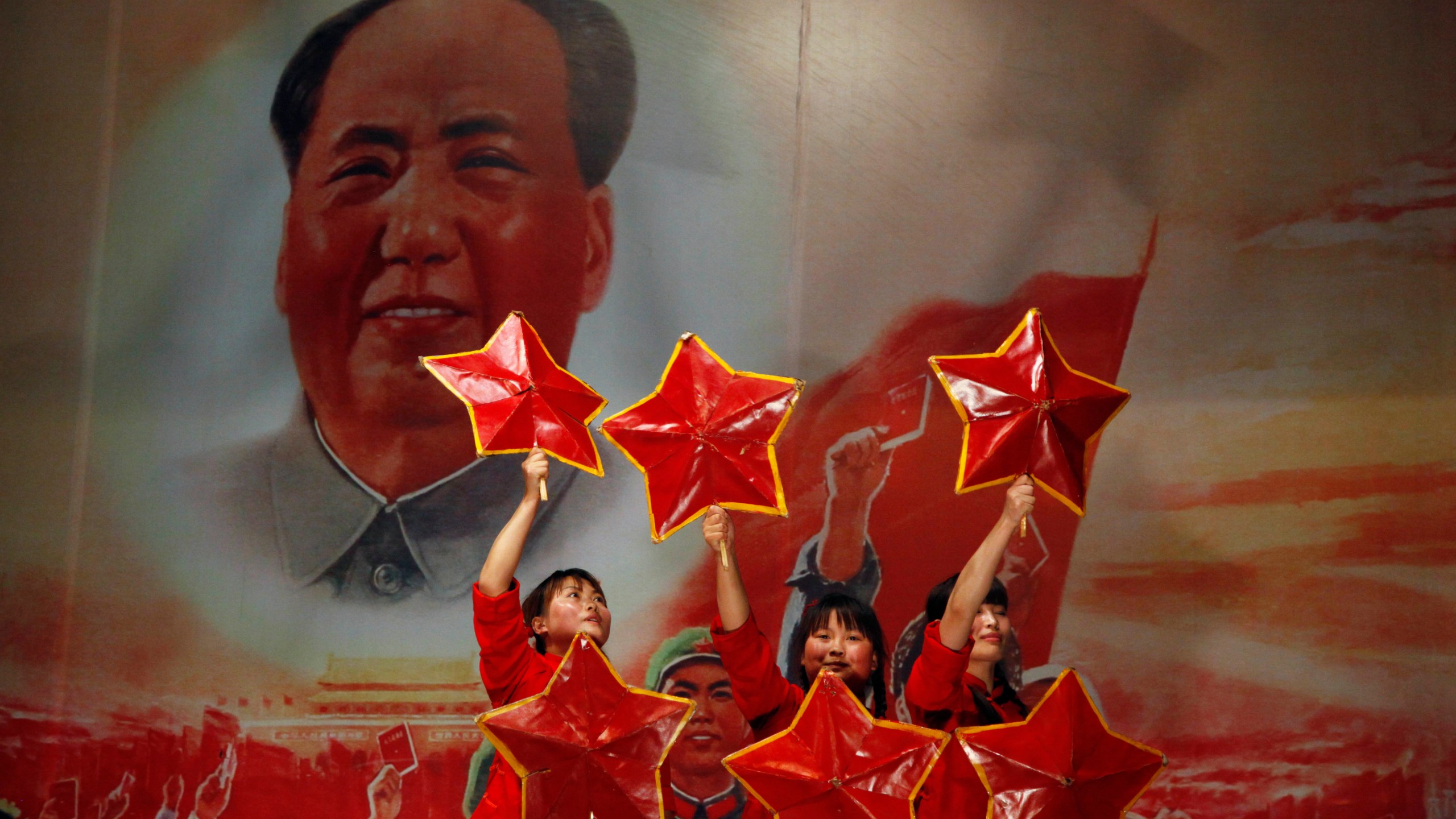 FILE - Performers take to the stage near a picture of Mao Zedong at the Red Classic restaurant that capitalizes on nostalgia for China's past in Beijing, May 2, 2011. (AP Photo/Ng Han Guan, File)