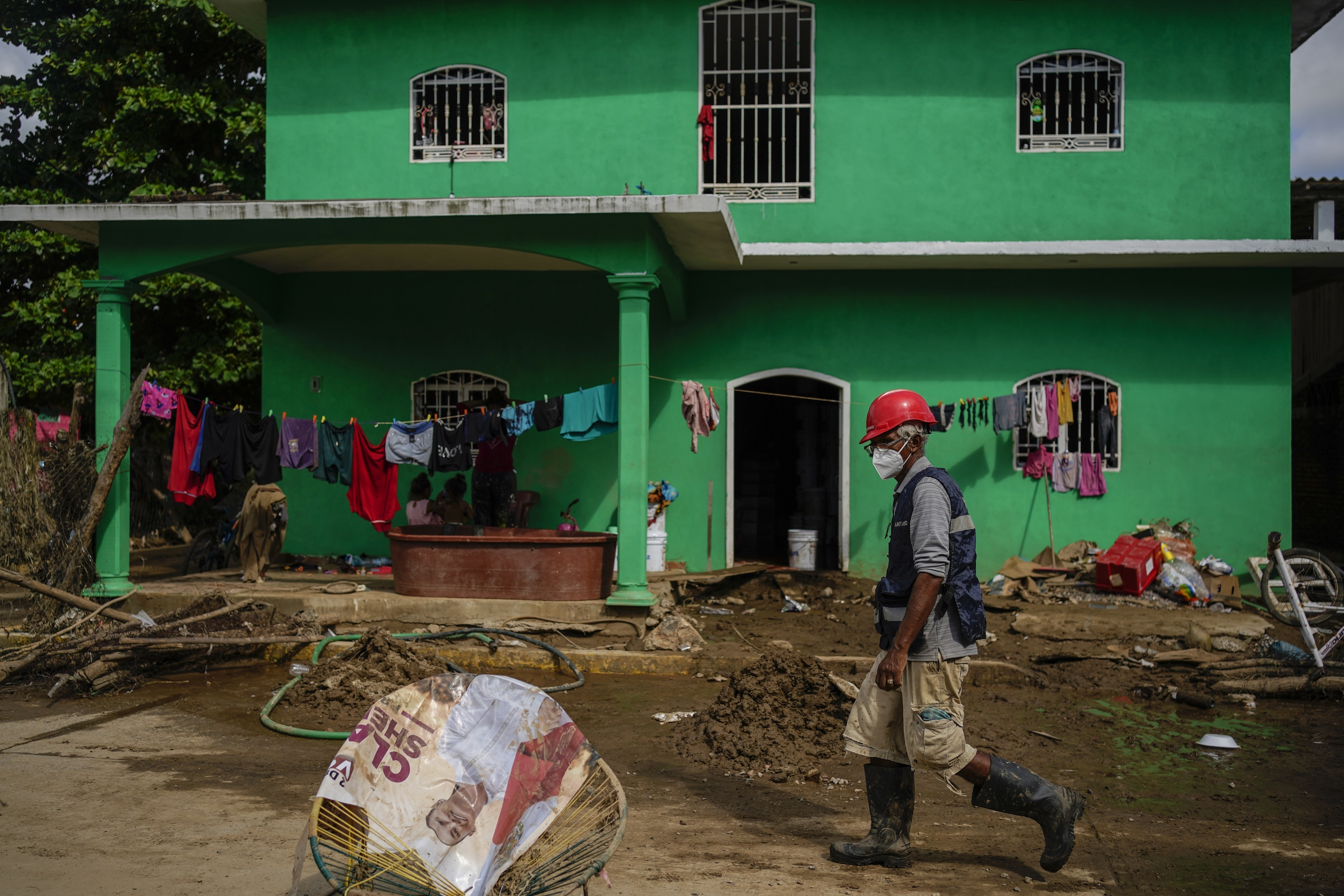 A volunteer inspects the damage in Coyuca de Benitez, Guerrero state, Mexico, after Hurricane John passed through, Monday, Sept. 30, 2024. (AP Photo/Felix Marquez)