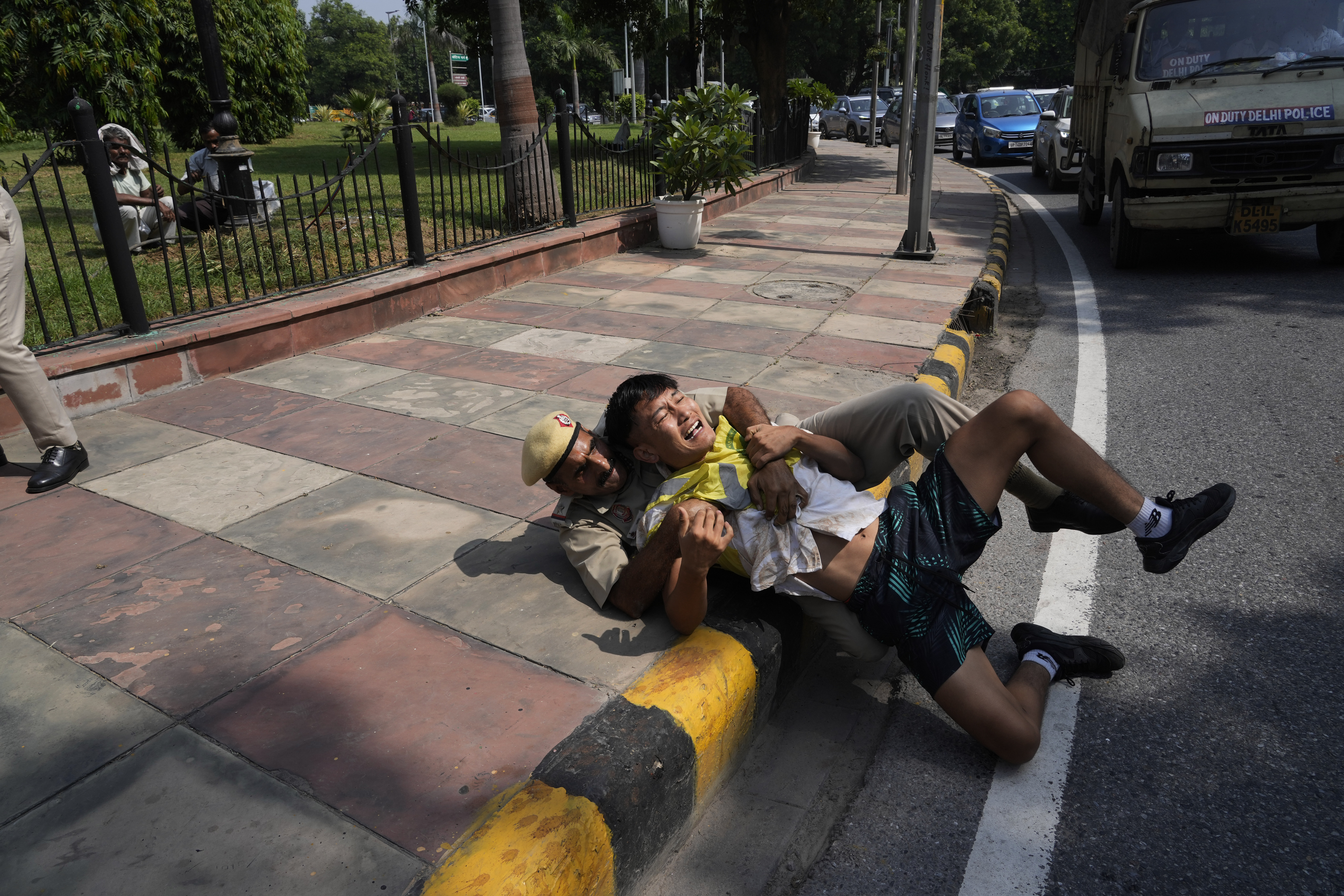 An Indian policeman detains an exile Tibetan protesting against the human rights situation in Tibet during a protest to coincide China marking its 75th year of Communist Party rule, outside Chinese embassy, in New Delhi, India, Tuesday, Oct. 1, 2024. (AP Photo/Manish Swarup)