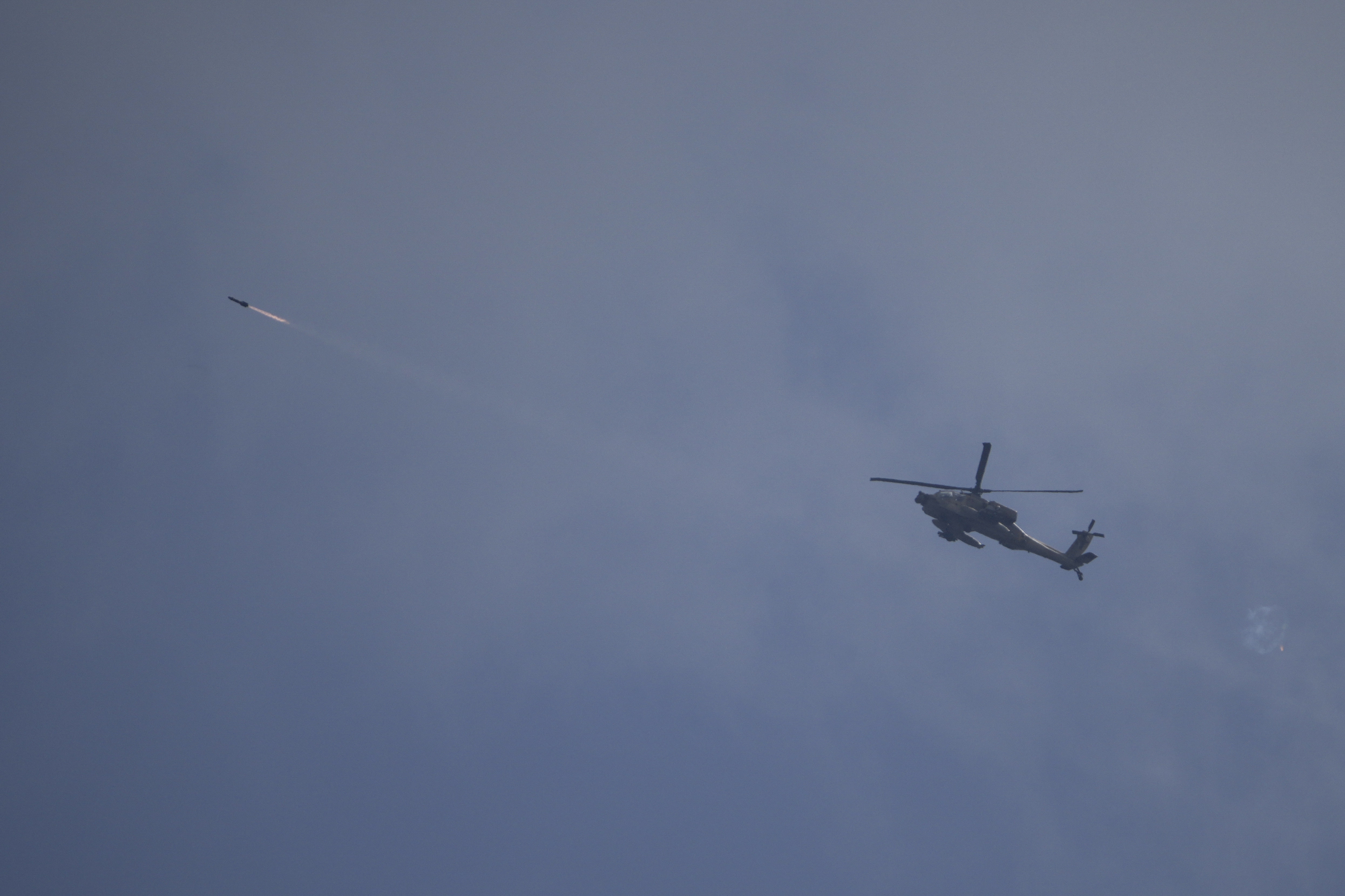 An Israeli Apache helicopter fires a missile towards southern Lebanon as seen from northern Israel, Tuesday, Oct. 1, 2024. (AP Photo/Leo Correa)