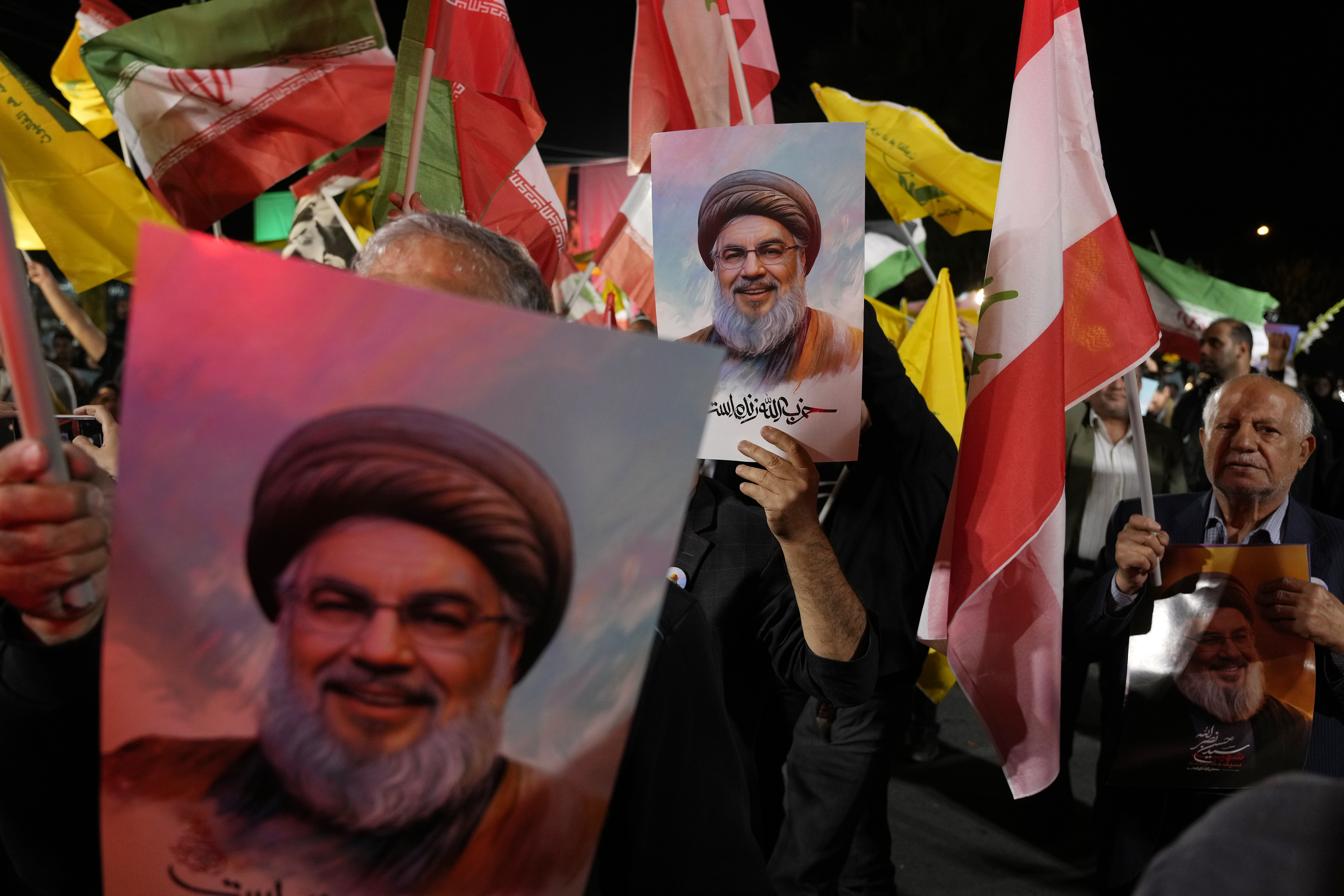 Iranian demonstrators hold posters of slain Hezbollah leader Hassan Nasrallah during an anti-Israeli protest at Felestin (Palestine) Square in Tehran, Iran, Tuesday, Oct. 1, 2024. (AP Photo/Vahid Salemi)