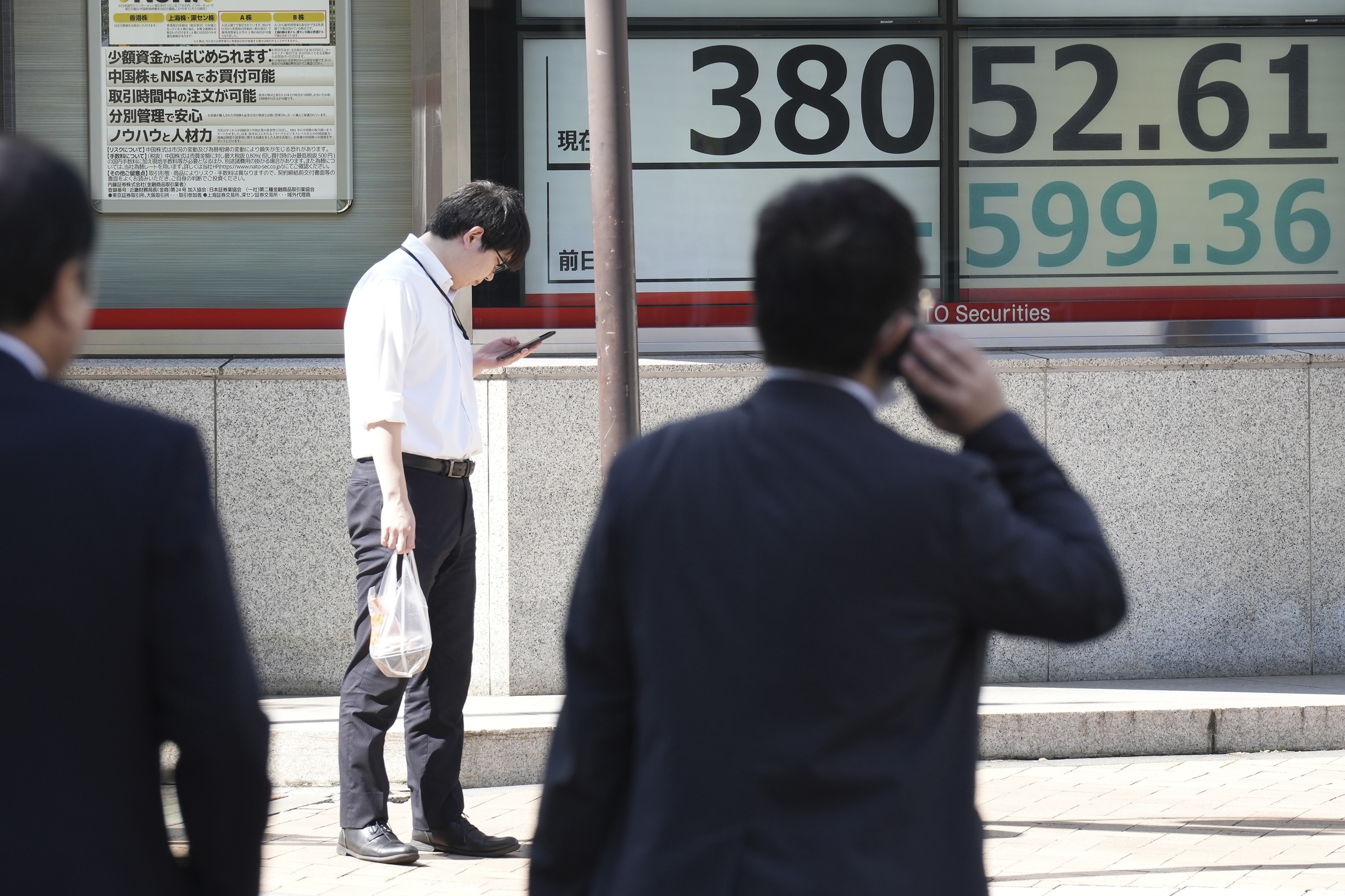 People stand in front of an electronic stock board showing Japan's Nikkei index at a securities firm Wednesday, Oct. 2, 2024, in Tokyo. (AP Photo/Eugene Hoshiko)