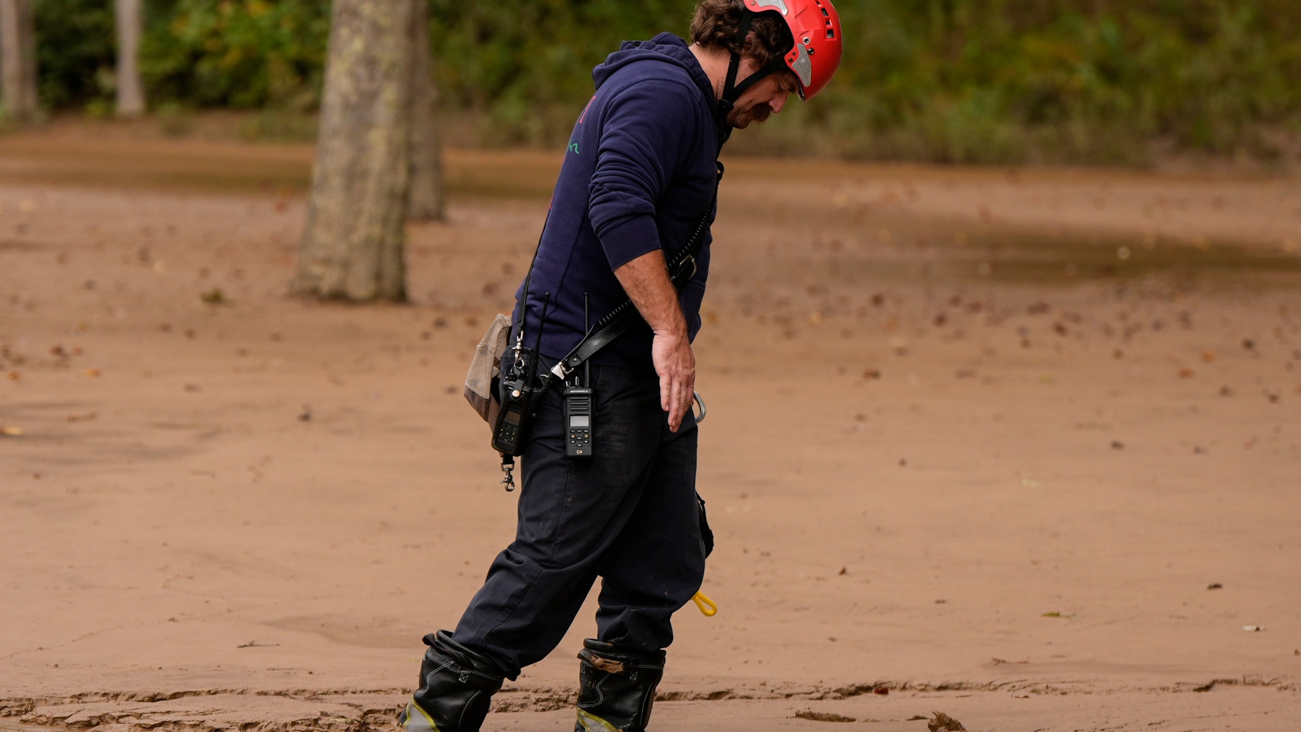 A fireman walks through mud as they search for victims of flash flooding in the aftermath of Hurricane Helene, Tuesday, Oct. 1, 2024, in Swannanoa, N.C. (AP Photo/Mike Stewart)