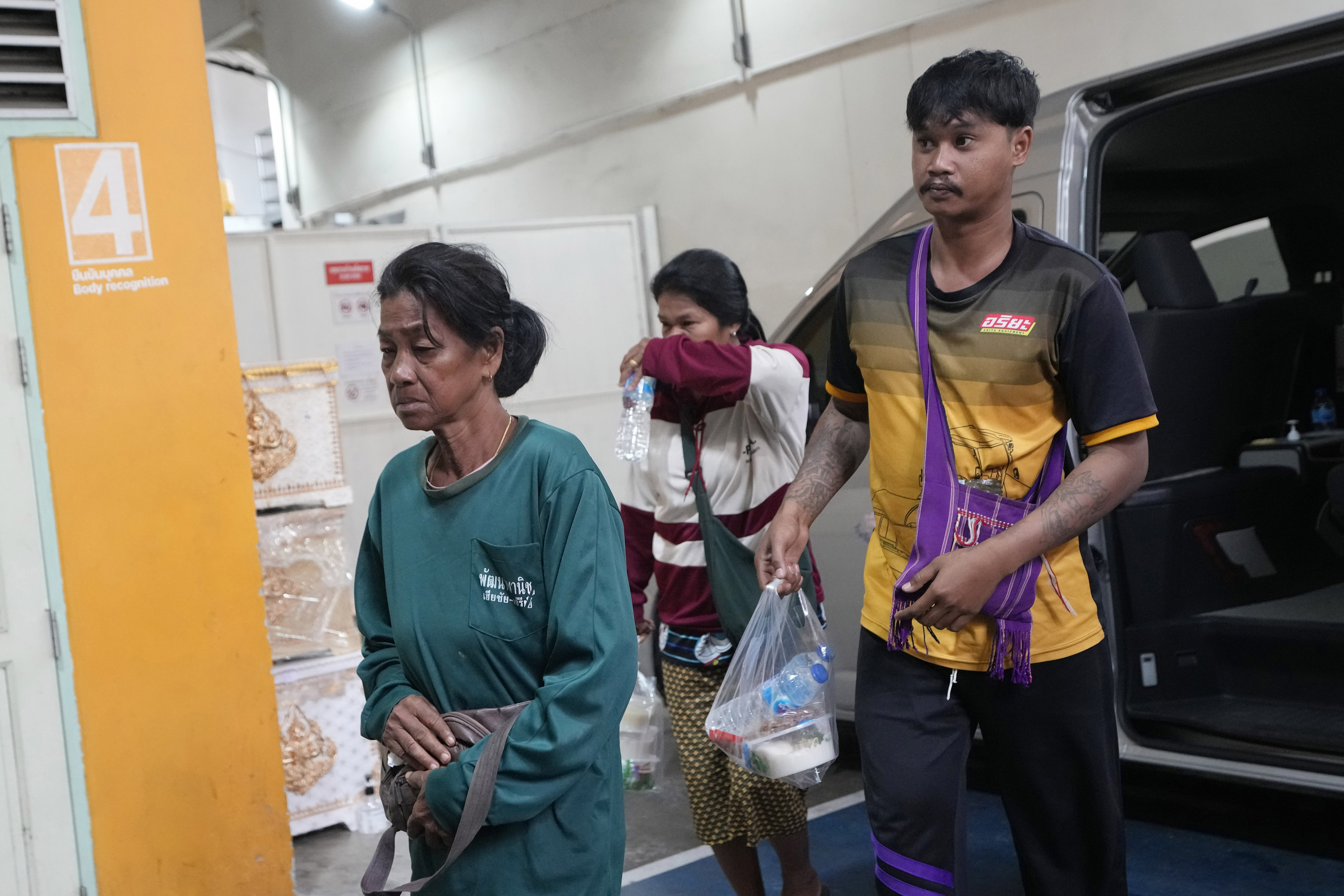 Family members of a victim arrive at a forensic police hospital in Bangkok, Thailand, Wednesday, Oct. 2, 2024, after a bus carrying students and teachers caught a fire Tuesday. (AP Photo/Sakchai Lalit)