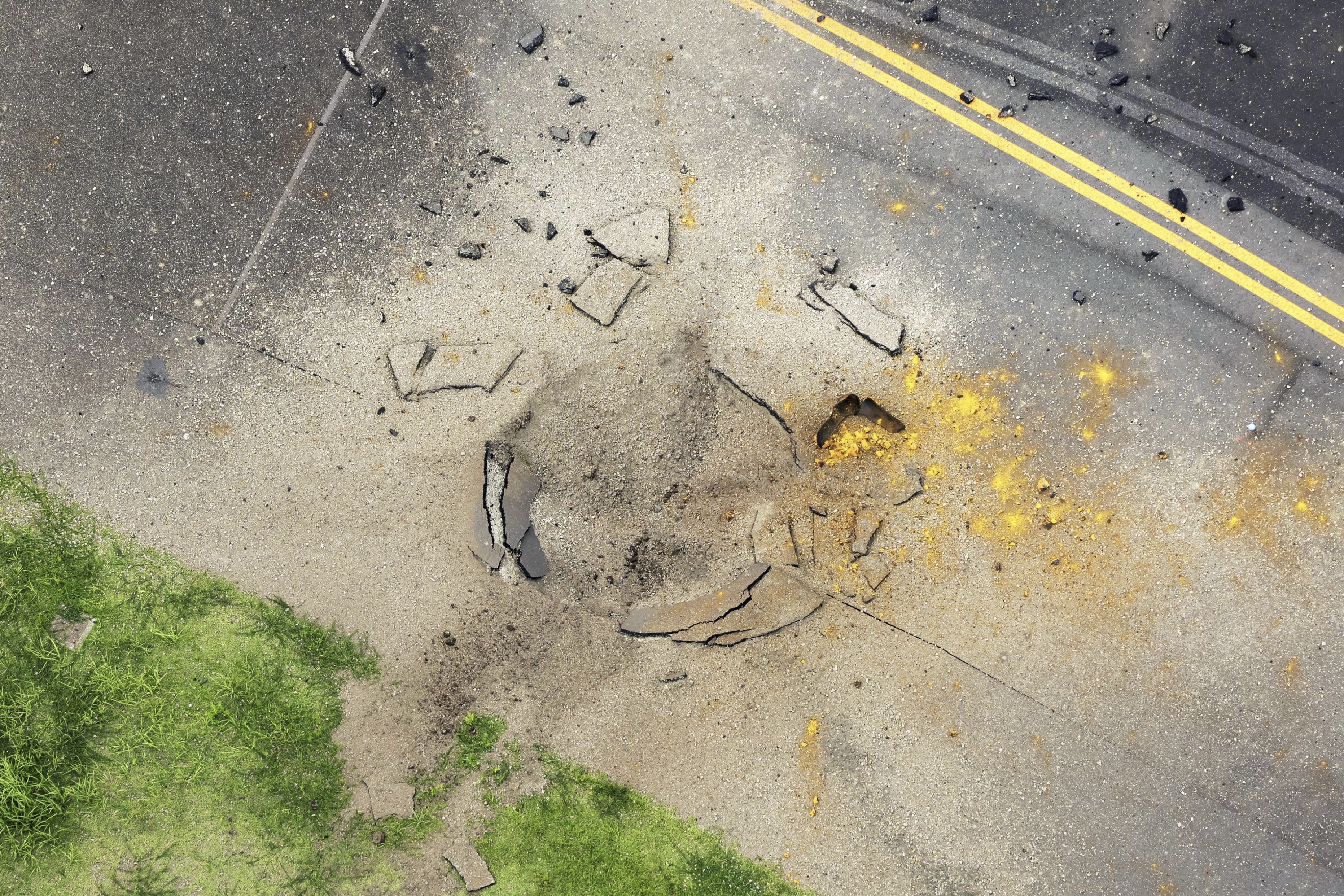 This photo taken from a Kyodo News helicopter shows part of a damaged taxiway at Miyazaki Airport in southwestern Japan, Wednesday, Oct. 2, 2024, after an explosion was reported. (Kyodo News via AP)