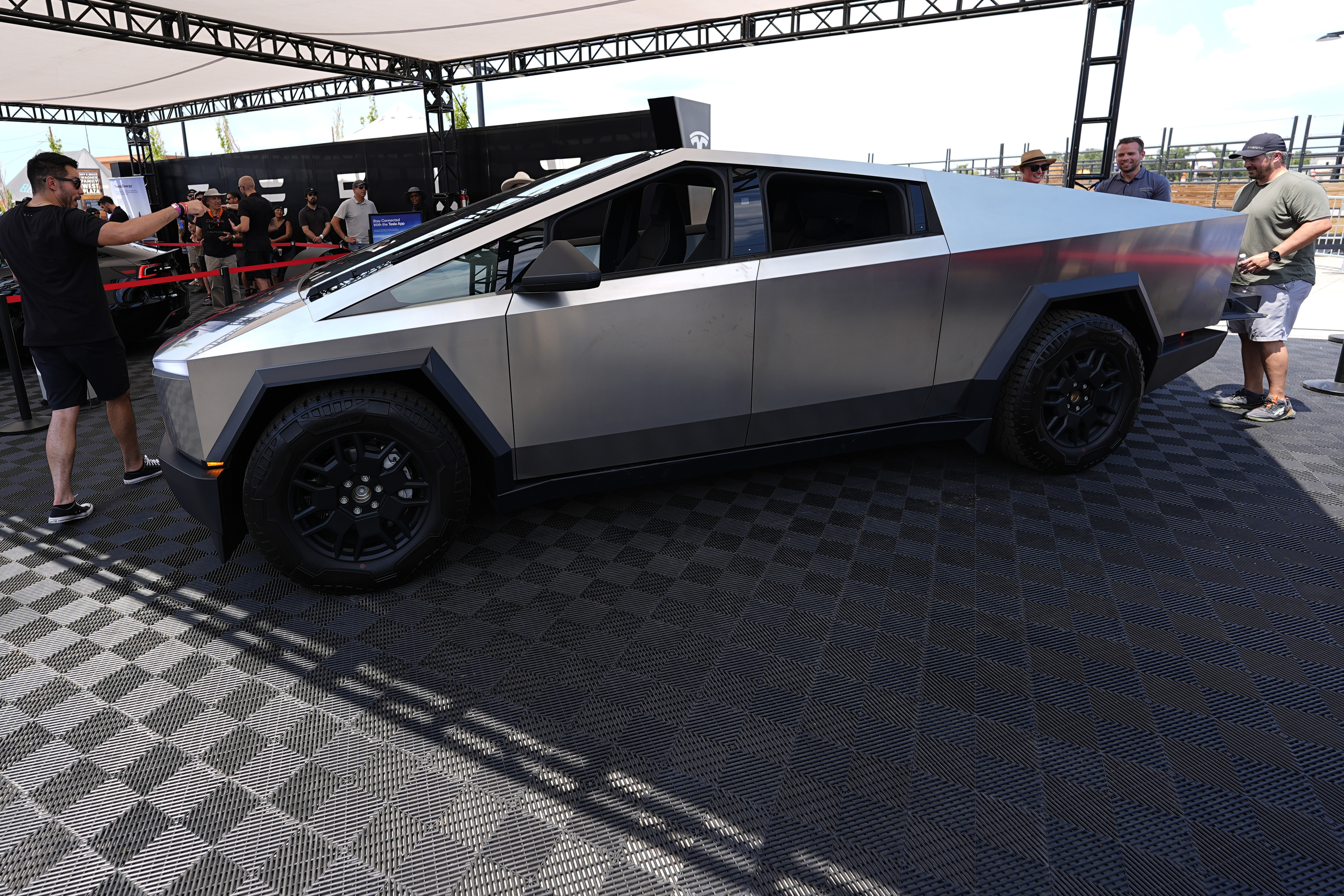 FILE - Visitors look over a 2024 Cybertruck in the Tesla display at the Electrify Expo, July 14, 2024, in north Denver. (AP Photo/David Zalubowski, File)