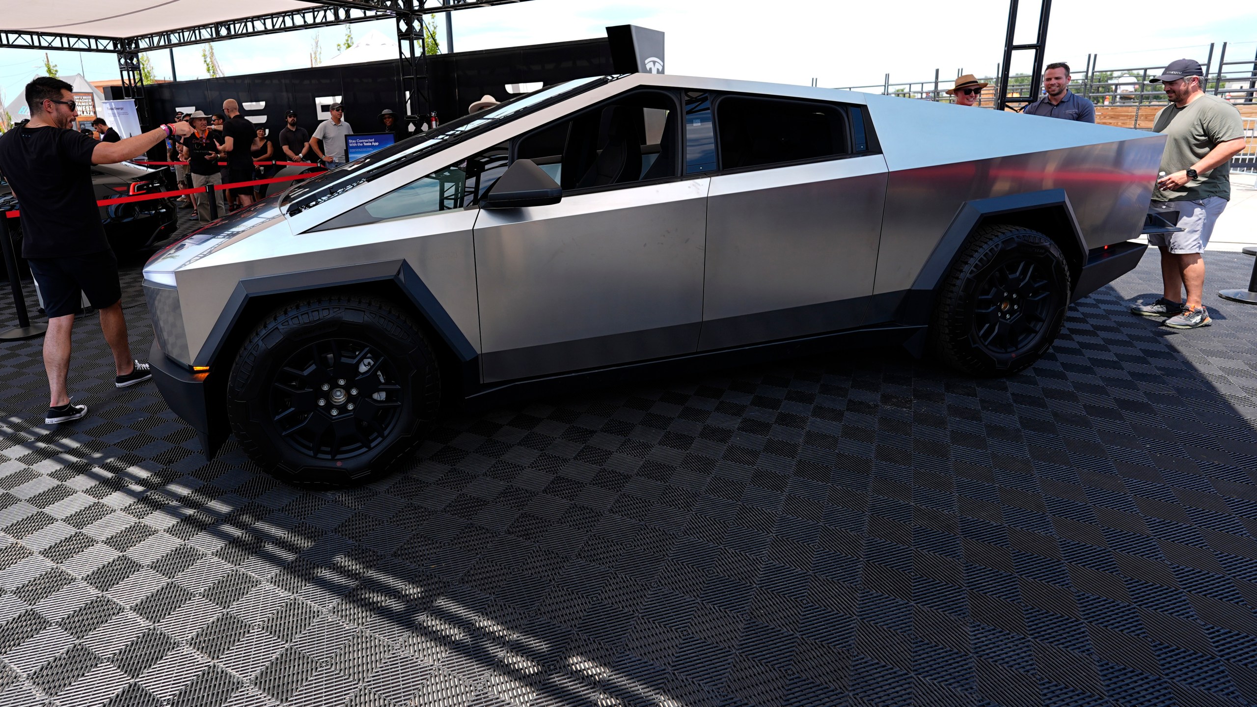 FILE - Visitors look over a 2024 Cybertruck in the Tesla display at the Electrify Expo, July 14, 2024, in north Denver. (AP Photo/David Zalubowski, File)