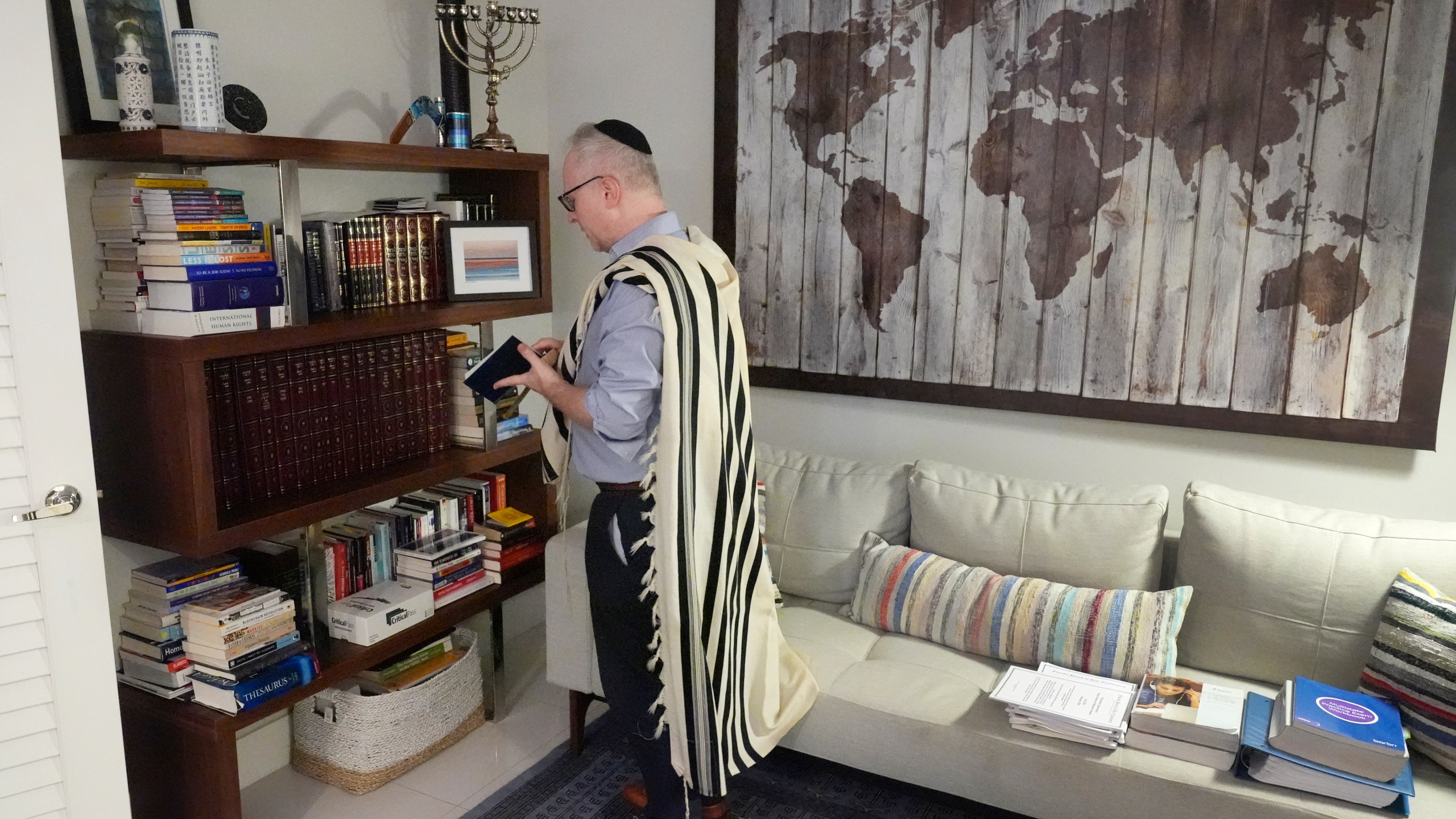 Daniel Gammerman gathers prayer items that he will use to privately worship at home during the Jewish High Holy Days, Thursday, Sept. 26, 2024, in Miami. (AP Photo/Wilfredo Lee)