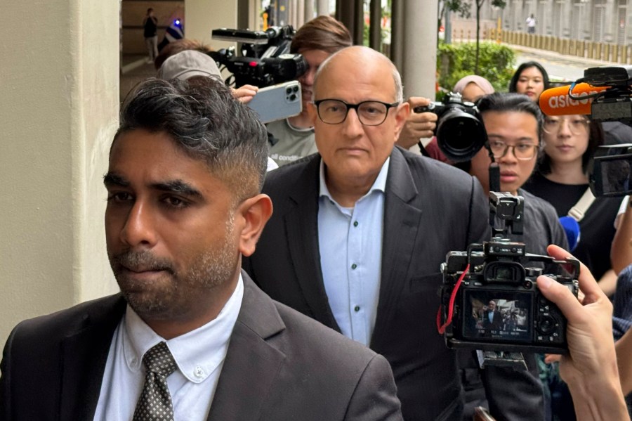 Former Transport Minister S. Iswaran, center, and his lawyer Navin Thevar arrive at the High Court in Singapore, July 5, 2024. (AP Photo)