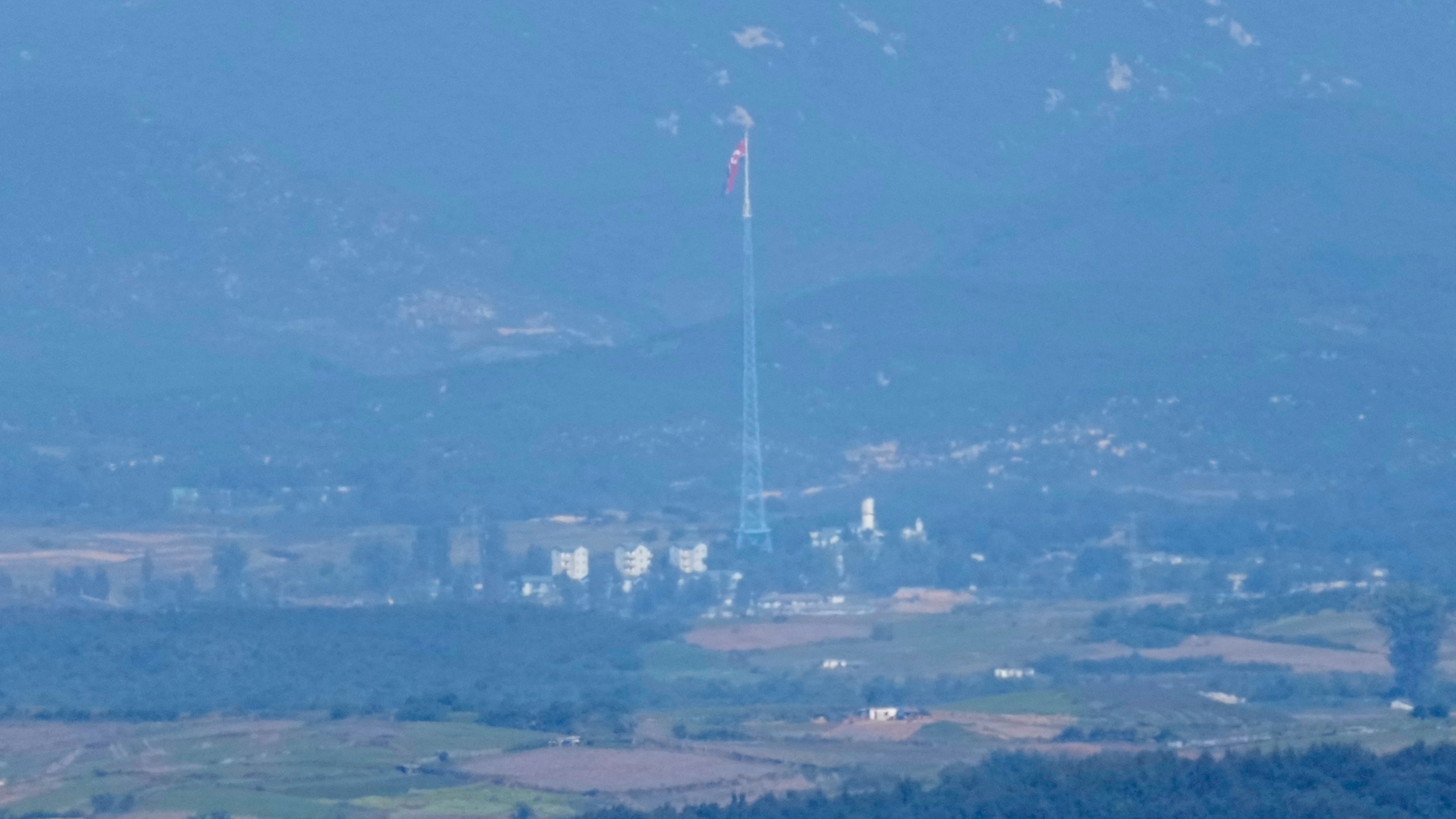 A North Korean flag flutters in the wind atop a 160-meter (525-foot) tower in the North's Kijong-dong village near the truce village of Panmunjom, seen from Paju, South Korea, near the border with North Korea, Friday, Oct. 4, 2024. (AP Photo/Lee Jin-man)