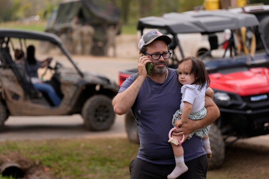 A man makes a call on the wireless system set up at the volunteer fire department in the aftermath of Hurricane Helene, Thursday, Oct. 3, 2024, in Pensacola, N.C. (AP Photo/Mike Stewart)