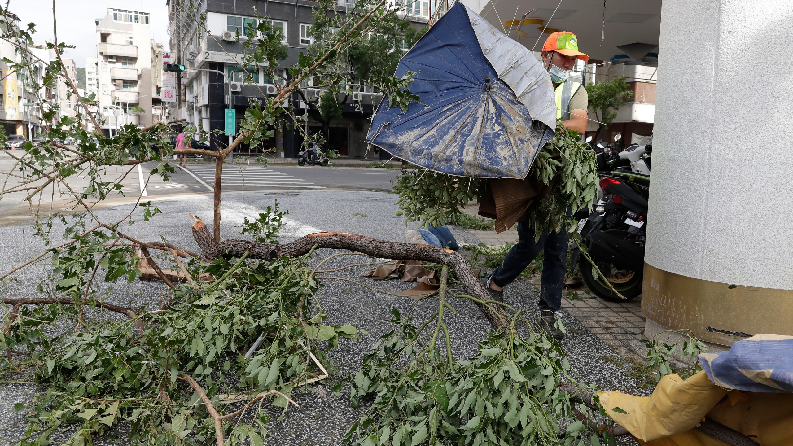 A sanitation worker of Kaohsiung city government clears debris in the aftermath of Typhoon Krathon in Kaohsiung, southern Taiwan, Friday, Oct. 4, 2024. (AP Photo/Chiang Ying-ying)