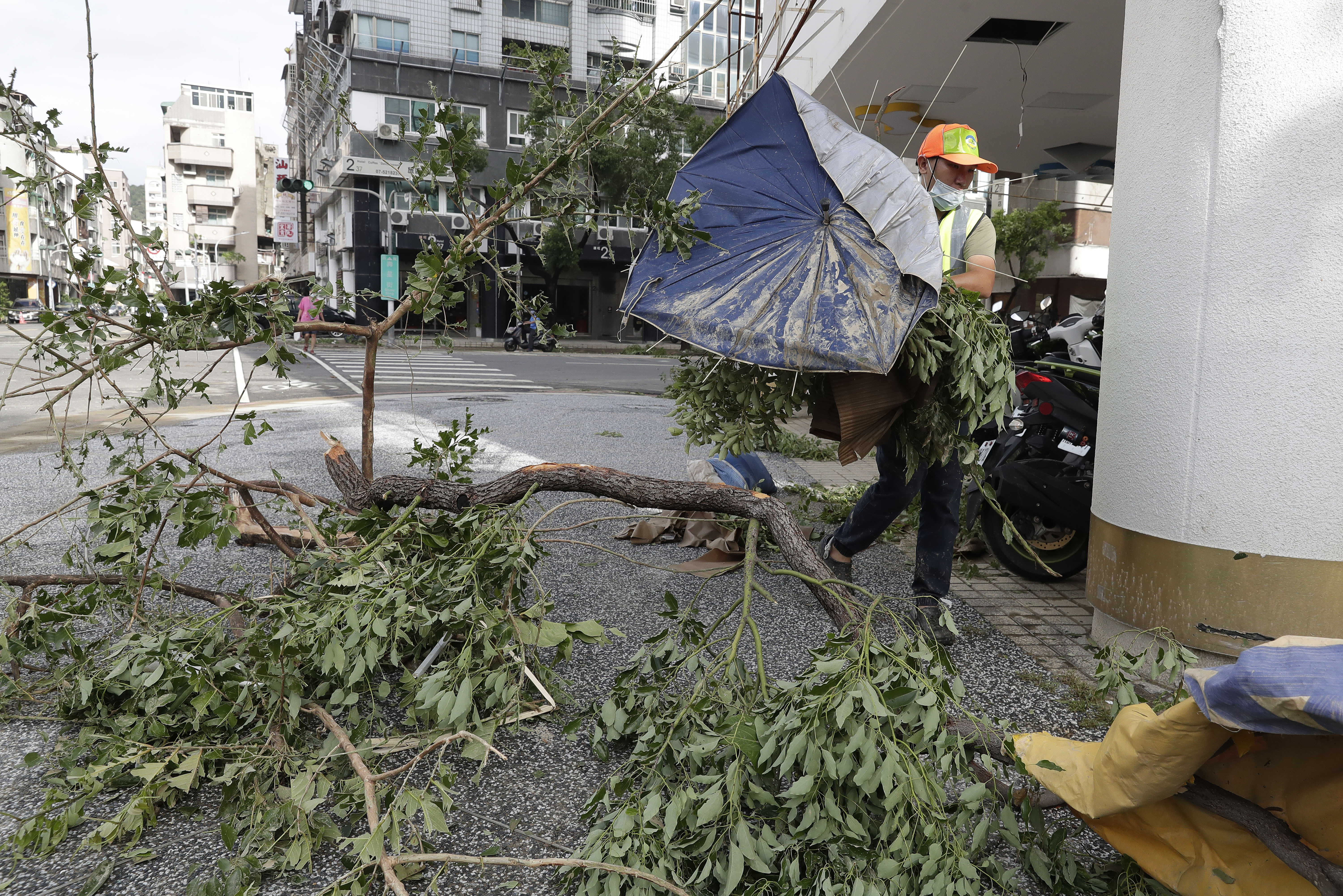 A sanitation worker of Kaohsiung city government clears debris in the aftermath of Typhoon Krathon in Kaohsiung, southern Taiwan, Friday, Oct. 4, 2024. (AP Photo/Chiang Ying-ying)