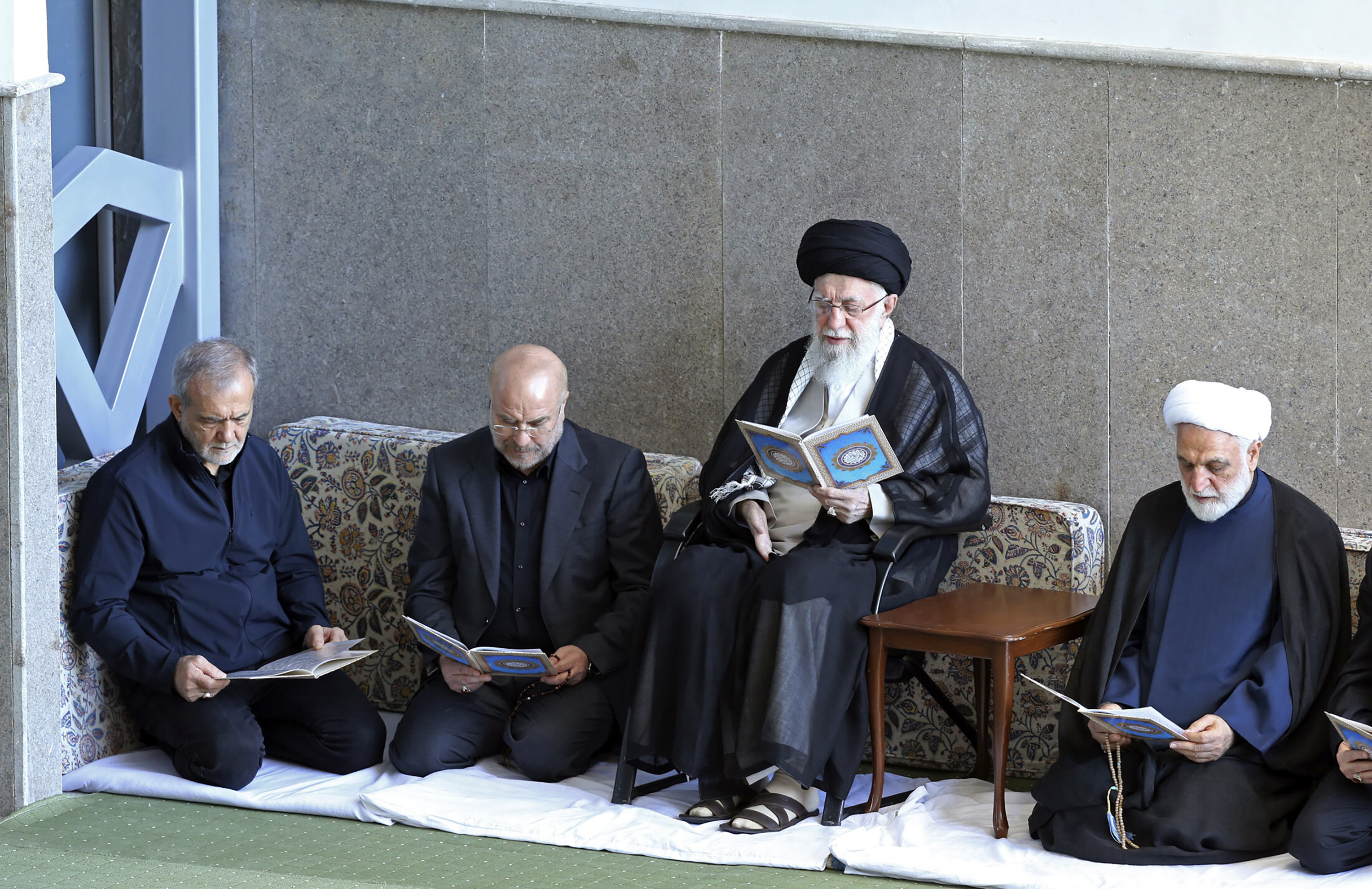 In this photo released by the official website of the office of the Iranian supreme leader, Supreme Leader Ayatollah Ali Khamenei, second right, Judiciary Chief Gholam Hossein Mohseni Ejehei, right, Parliament Speaker Mohammad Bagher Qalibaf, second left, and President Masoud Pezeshkian read Quran in a ceremony commemorating slain Hezbollah leader Hassan Nasrallah, at Imam Khomeini grand mosque in Tehran, Iran, Friday, Oct. 4, 2024. (Office of the Iranian Supreme Leader via AP)