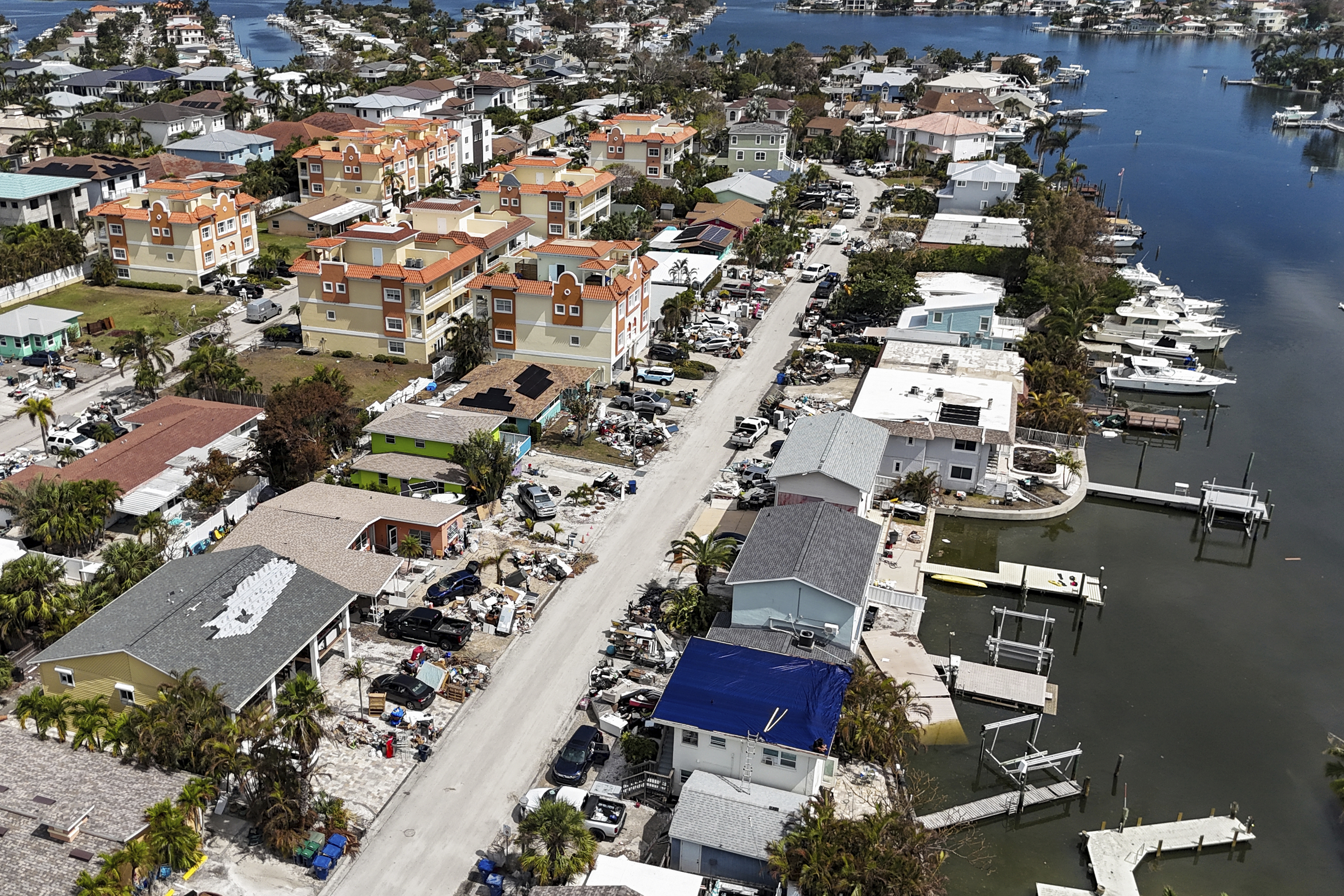 Contents of homes line the streets after flooding from Hurricane Helene on Wednesday, Oct. 2, 2024, in Reddington Shores, Fla. (AP Photo/Mike Carlson)