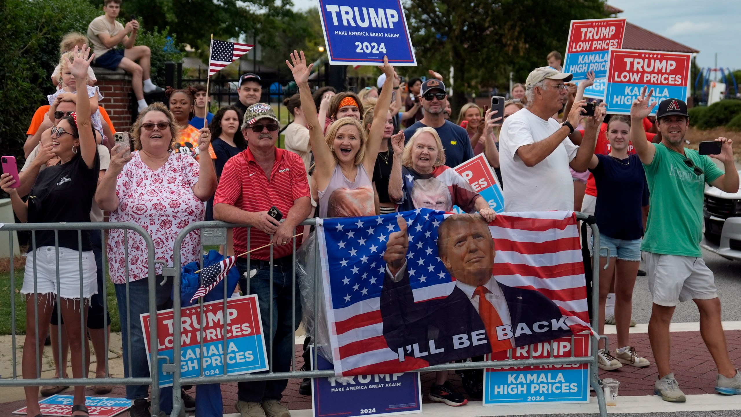 People line the road as Republican presidential nominee former President Donald Trump arrives to speak at a temporary relief shelter as he visits areas impacted by Hurricane Helene, Friday, Oct. 4, 2024, in Evans, Ga. (AP Photo/Evan Vucci)