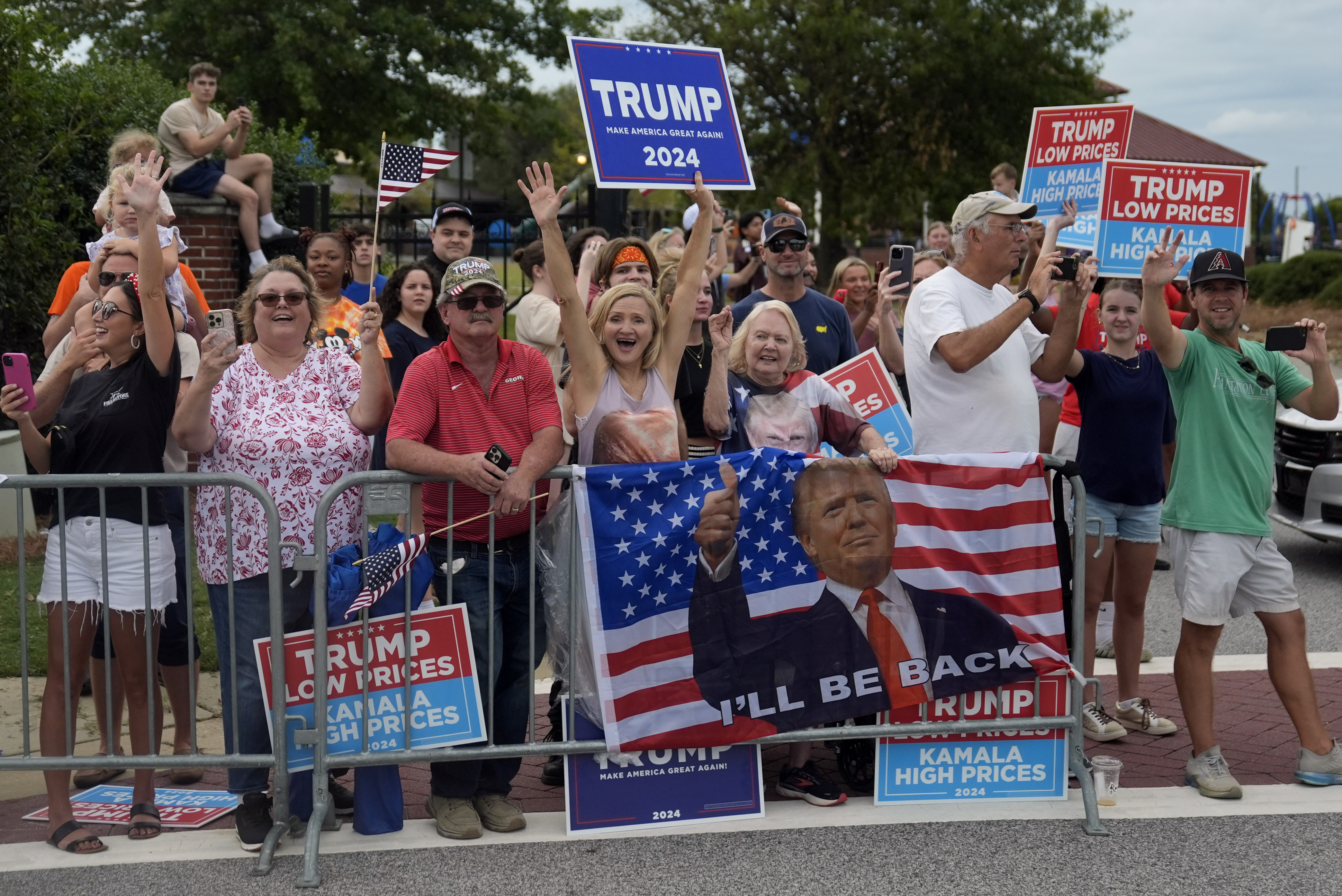 People line the road as Republican presidential nominee former President Donald Trump arrives to speak at a temporary relief shelter as he visits areas impacted by Hurricane Helene, Friday, Oct. 4, 2024, in Evans, Ga. (AP Photo/Evan Vucci)