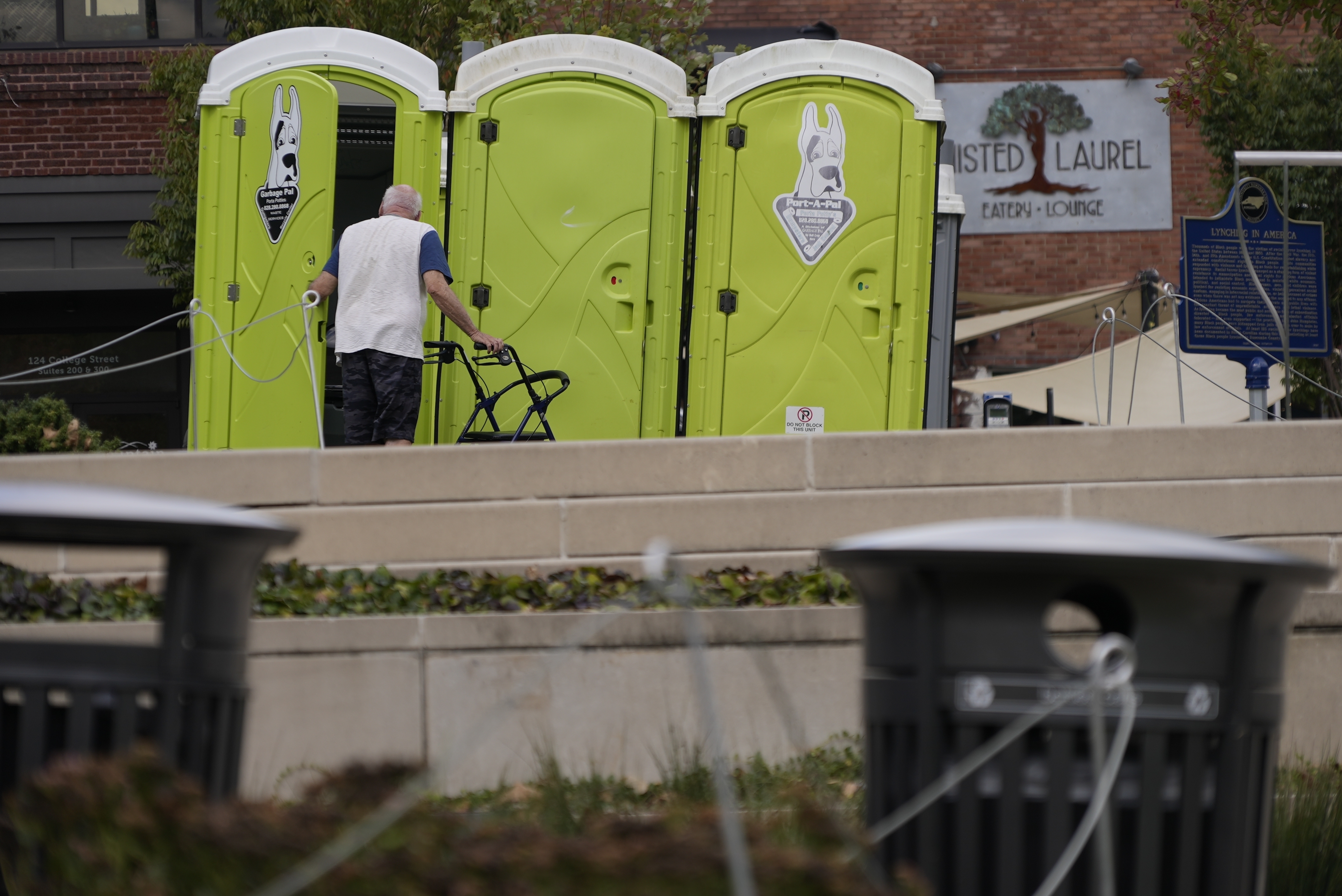 People use public toilets where there has been no water for the week since Hurricane Helene struck the region and damaged critical infrastructure, Thursday, Oct. 3, 2024 in Asheville, N.C. (AP Photo/Brittany Peterson)