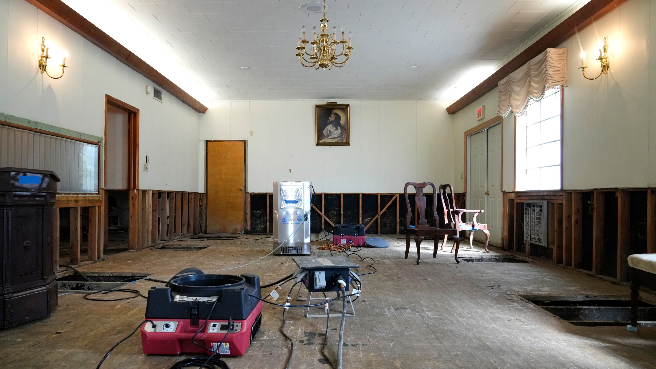 Air movers circulate the air in an effort to dry out the chapel inside Costner-Maloy Funeral Home Saturday, Oct. 5, 2024, which was flooded in the aftermath of Hurricane Helene, in Newport, Tenn. (AP Photo/Jeff Roberson)