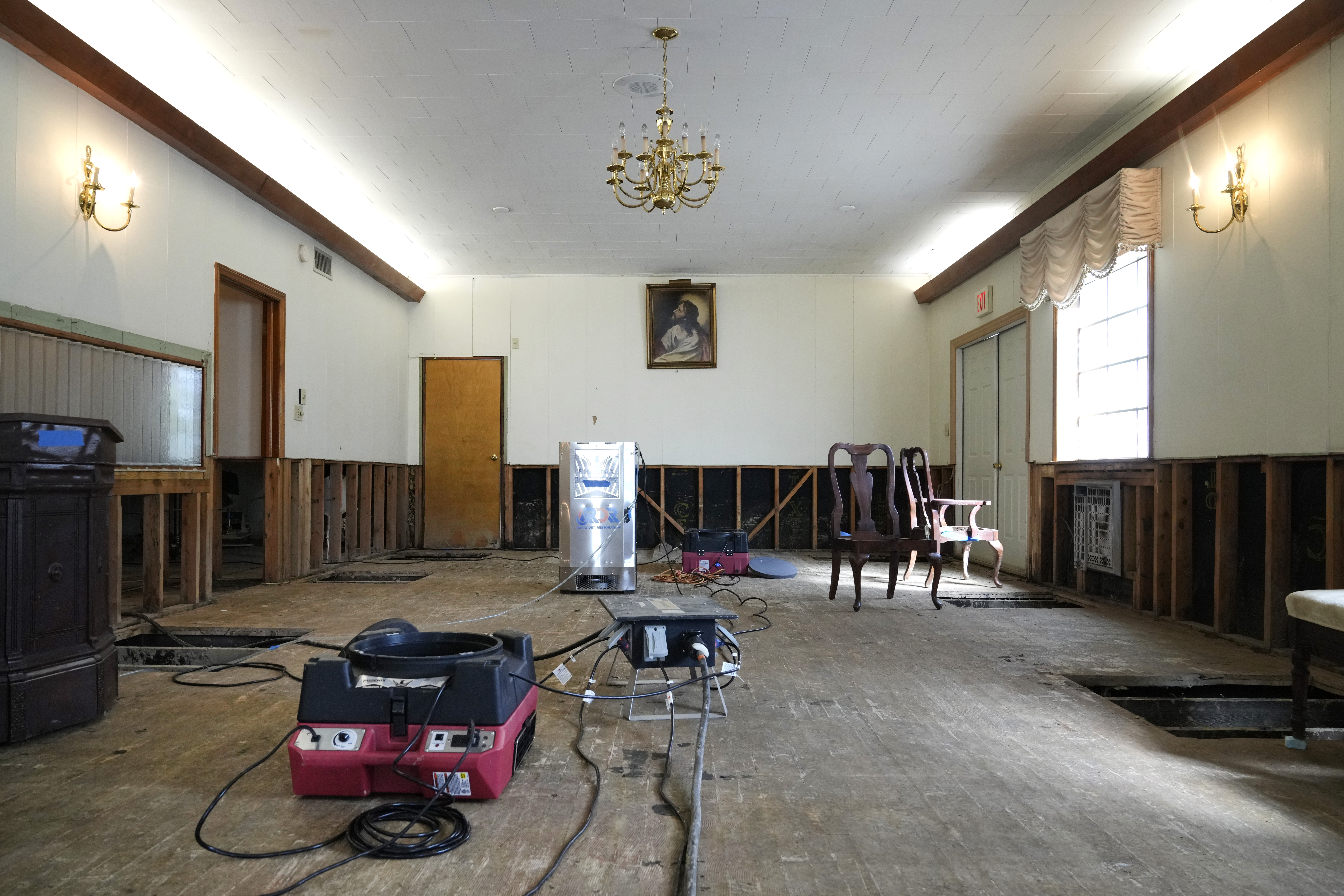 Air movers circulate the air in an effort to dry out the chapel inside Costner-Maloy Funeral Home Saturday, Oct. 5, 2024, which was flooded in the aftermath of Hurricane Helene, in Newport, Tenn. (AP Photo/Jeff Roberson)