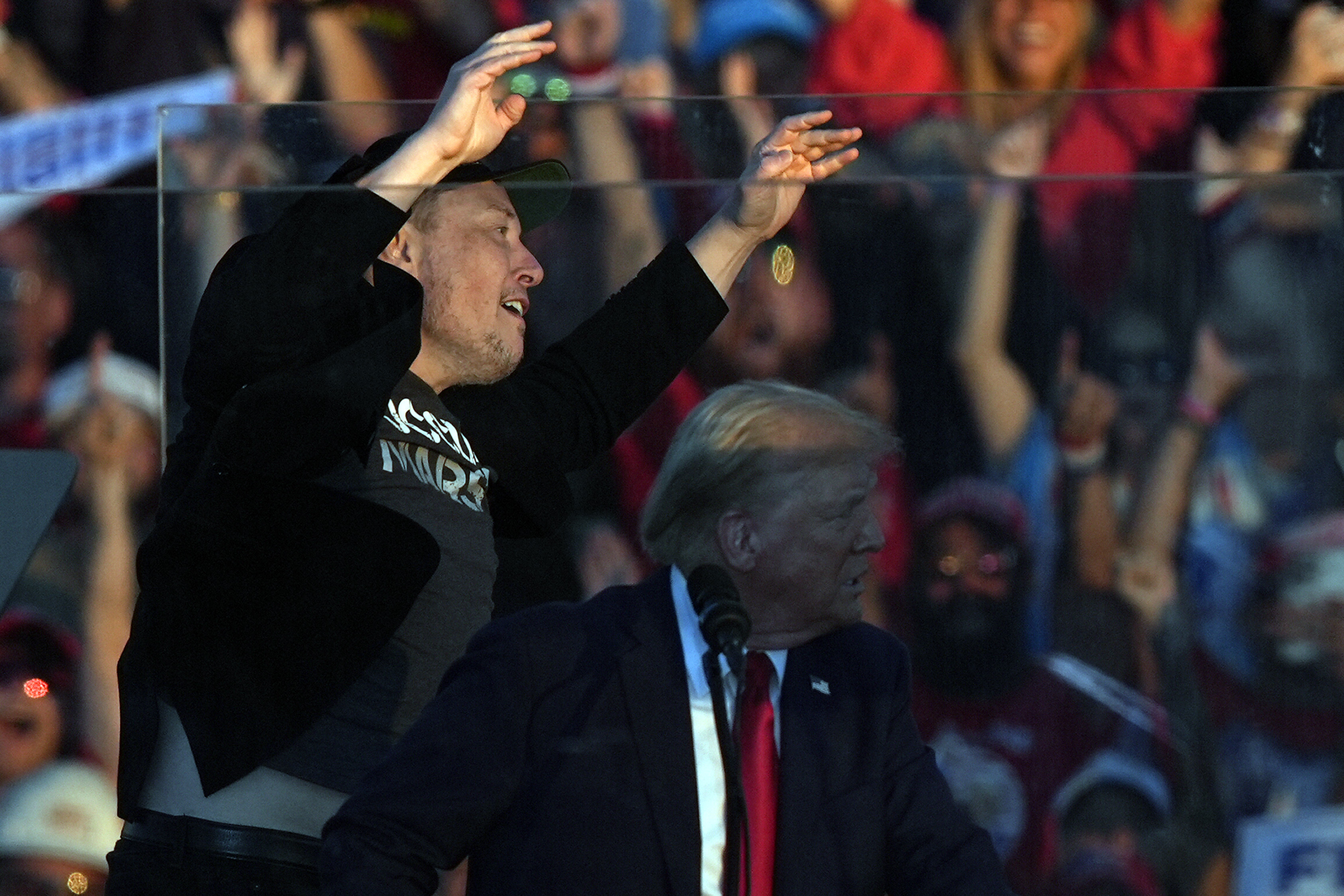 Elon Musk jumps on the stage behind Republican presidential nominee former President Donald Trump during a campaign rally at the Butler Farm Show, Saturday, Oct. 5, 2024, in Butler, Pa. (AP Photo/Julia Demaree Nikhinson)