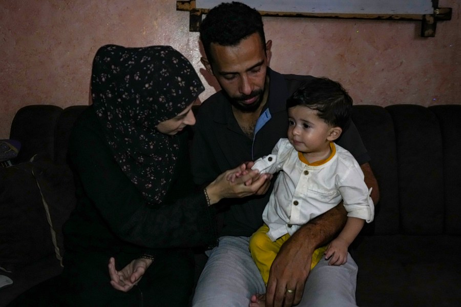 Amal and Mustafa Al-Taweel play with their child Ali, who was born on October 7, at their home in Nuseirat, as the Israeli-Hamas war marks its one year anniversary, Gaza Strip, Saturday, Oct. 5, 2024. (AP Photo/Abdel Kareem Hana)