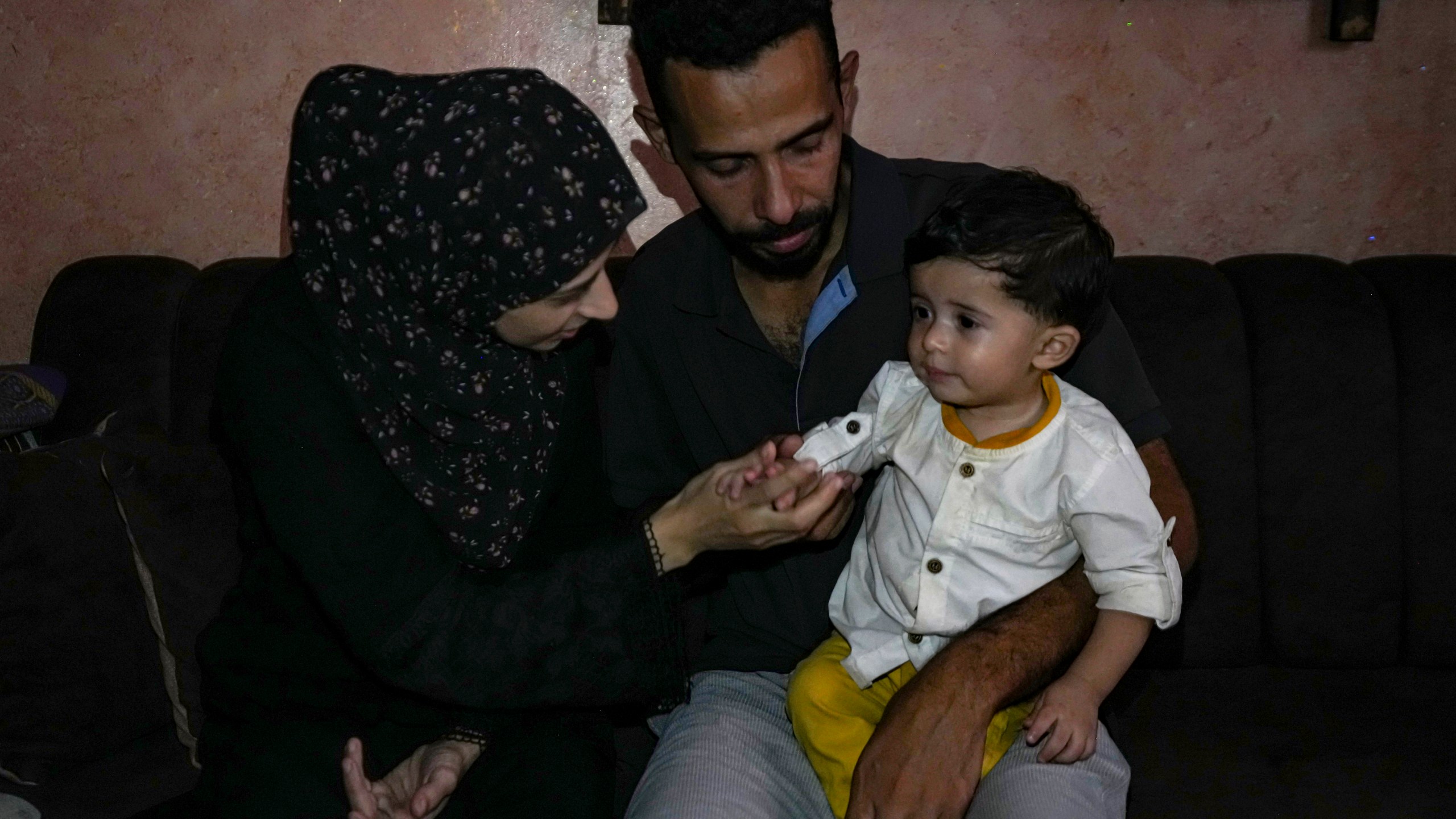 Amal and Mustafa Al-Taweel play with their child Ali, who was born on October 7, at their home in Nuseirat, as the Israeli-Hamas war marks its one year anniversary, Gaza Strip, Saturday, Oct. 5, 2024. (AP Photo/Abdel Kareem Hana)