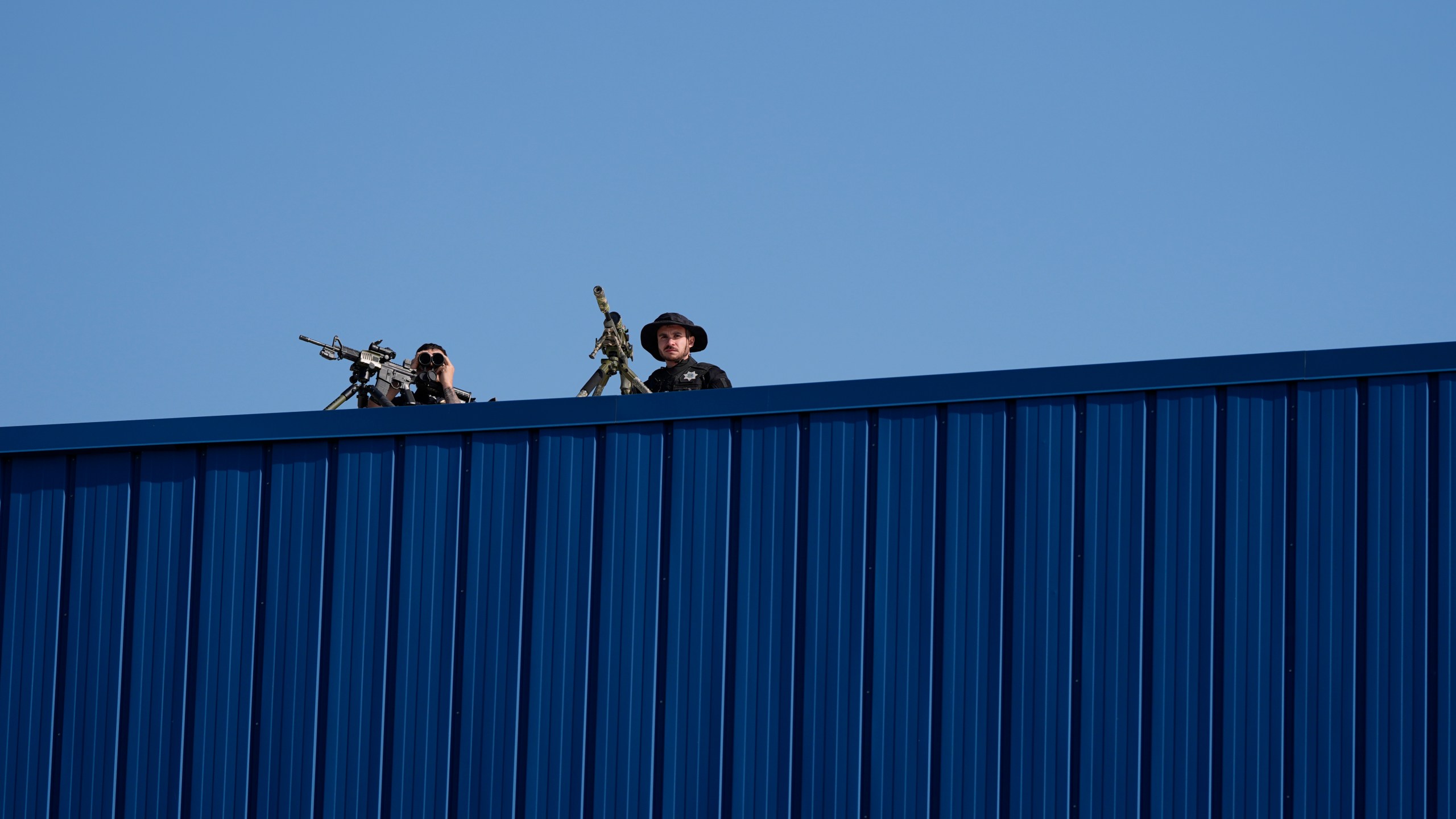 Law enforcement snipers sit on a roof before Republican presidential nominee former President Donald Trump arrives to speak at a campaign rally at Dodge County Airport, Sunday, Oct. 6, 2024, in Juneau, Wis. (AP Photo/Julia Demaree Nikhinson)