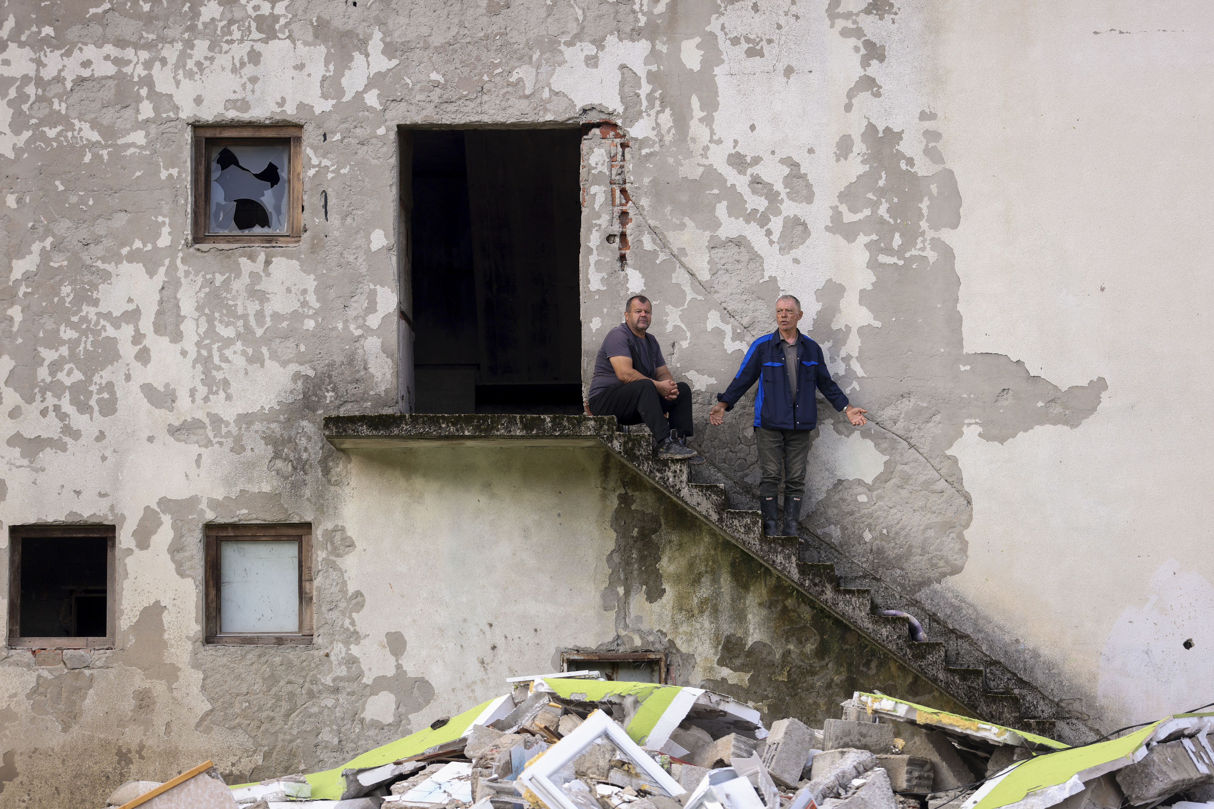 Men stand in despair in front of their destroyed house following a flooding in Buturovic Polje, Bosnia, Sunday, Oct. 6, 2024. (AP Photo/Armin Durgut)