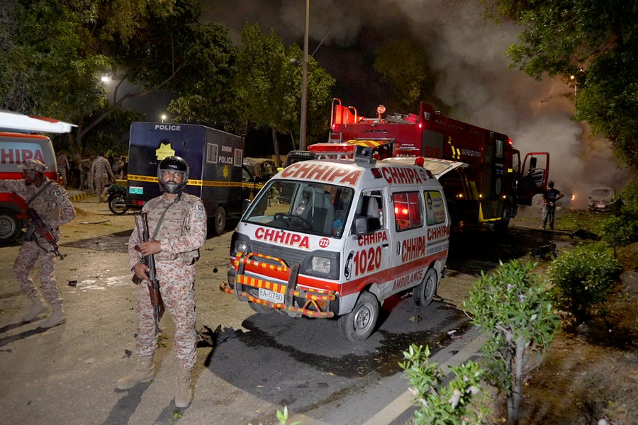 Paramilitary soldiers stand guard close to the site of an explosion that caused injuries and destroyed vehicles at outside the Karachi airport, Pakistan, Sunday, Oct. 6, 2024. (AP Photo/Mohammad Farooq)